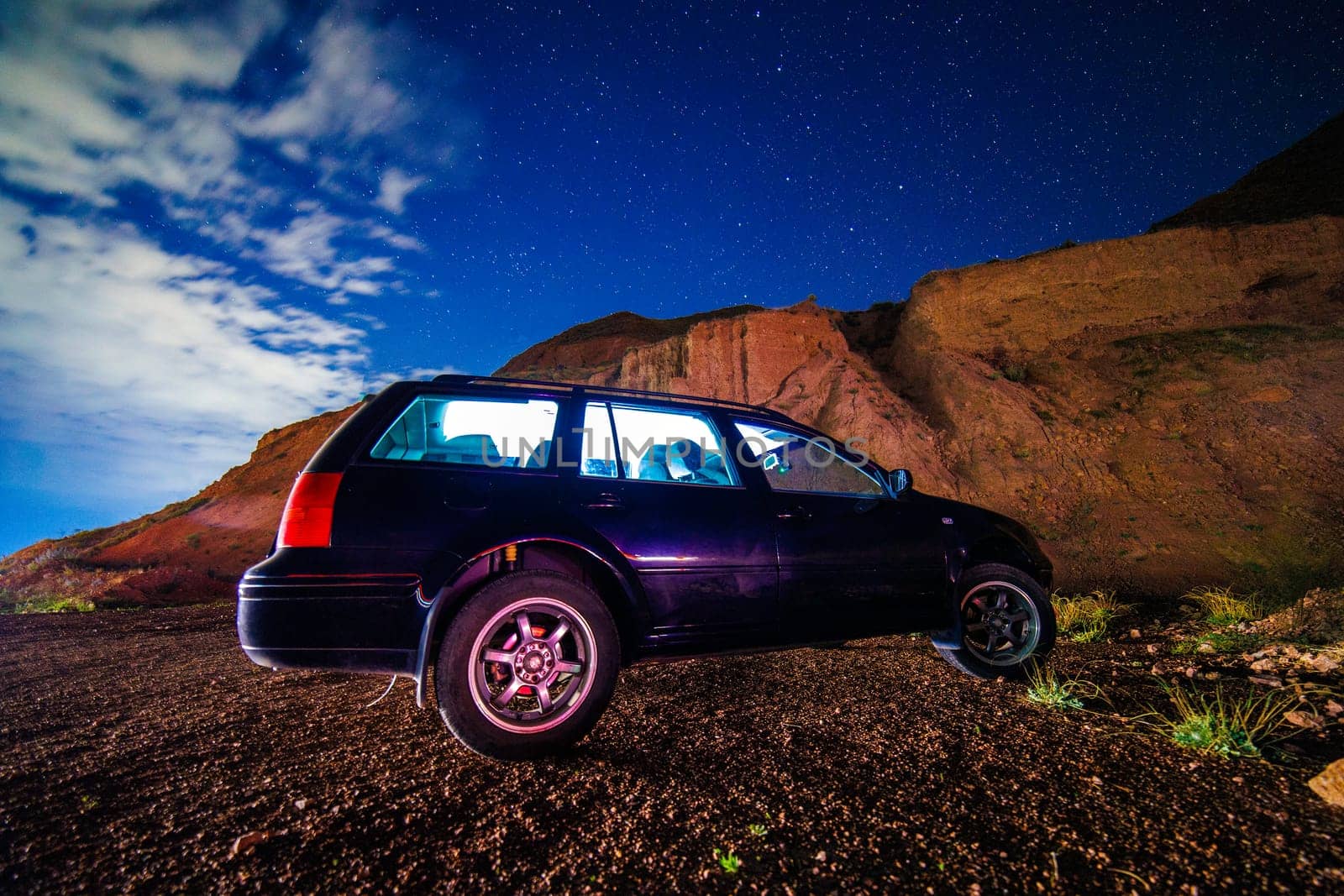 old black German station wagon car at starry summer night in the desert