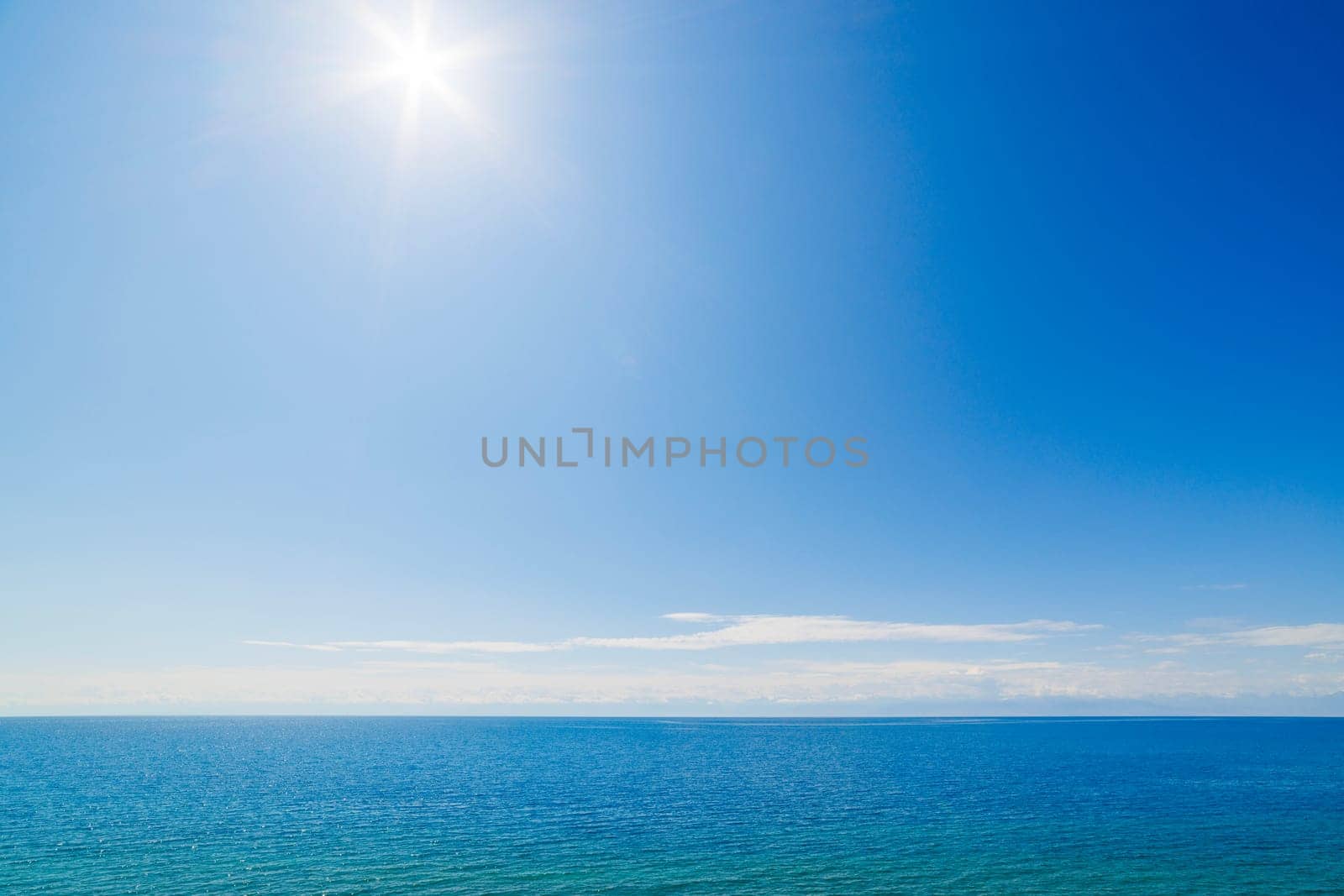 large open water surface with far snowcapped mountain range on the horizon at sunny day.