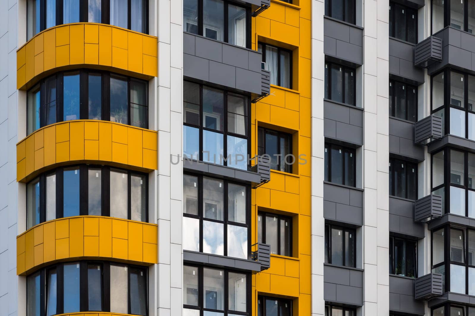 freshly built white-grey-yellow high rise apartment building, full-frame closeup.