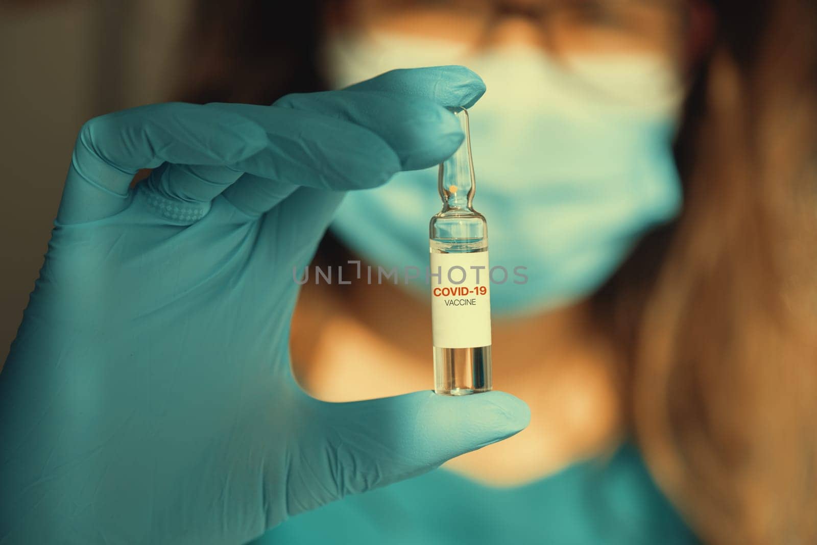 Coronavirus vaccine concept: covid-19 vaccine in doctor hand with blue protective gloves.
