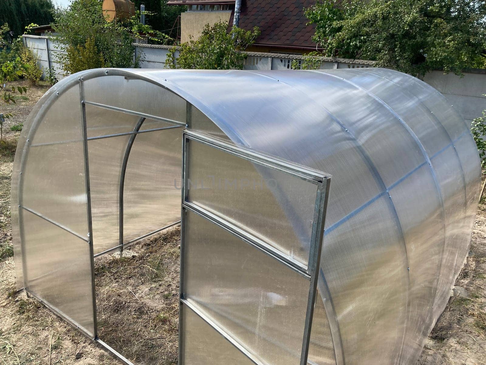 Installation of a metal frame greenhouse with the polycarbonate covering