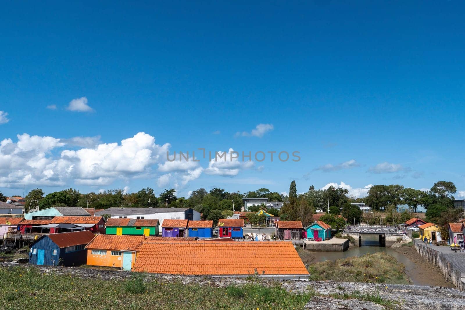 A colorful village with many houses and a river in the background, Oleron Island, France