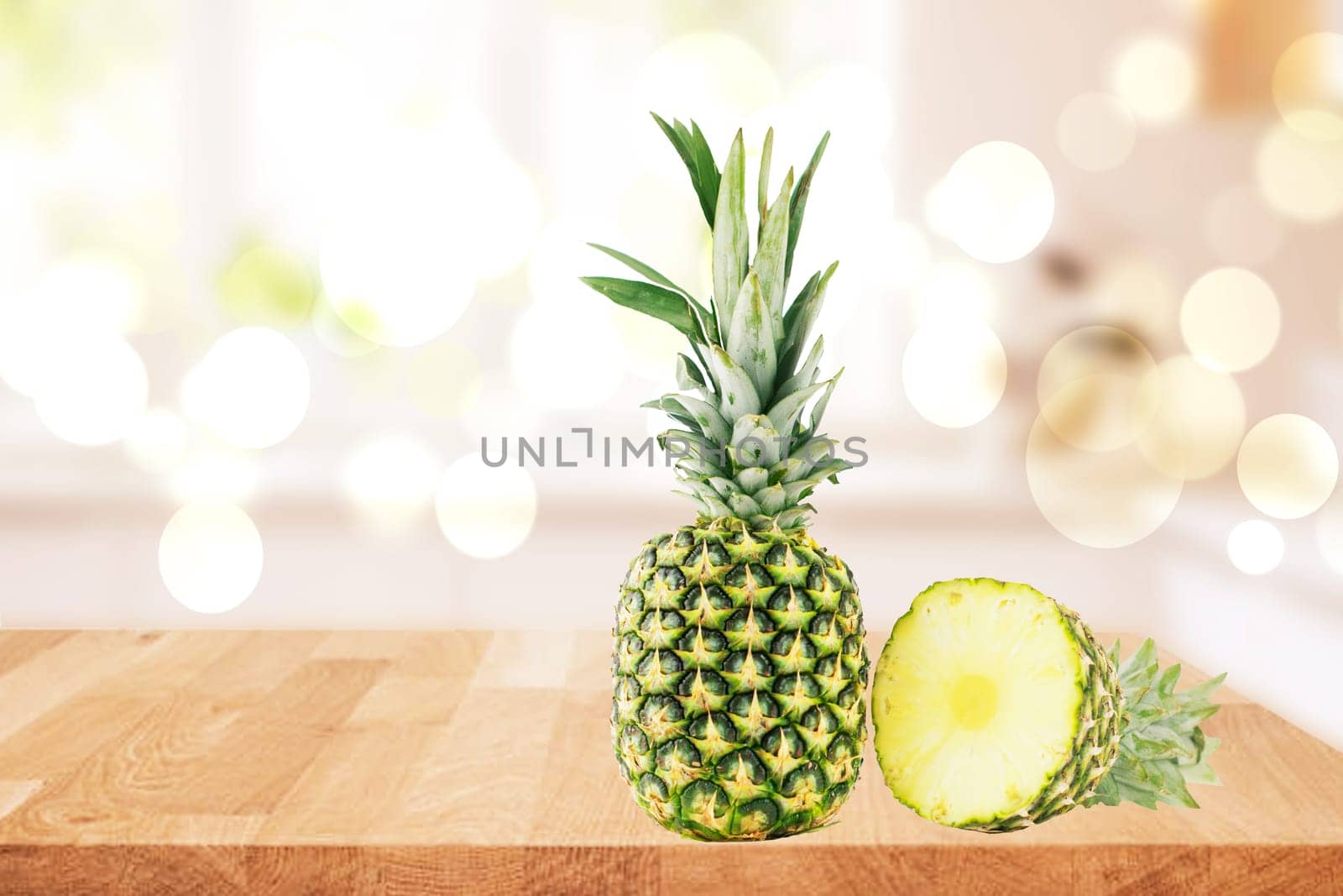 Fresh ripe pineapple fruits on a table over a abstract blurred bright natural windows background. Healthy nutrition. Tropical fruits or healthcare concept. Space for design.