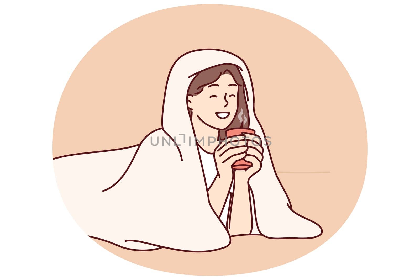 Girl with cup of hot coffee lies wrapped in blanket and smiles enjoying winter morning. Woman drinking hot drink with blanket to keep warm after walking on cold street for autumn mood concept