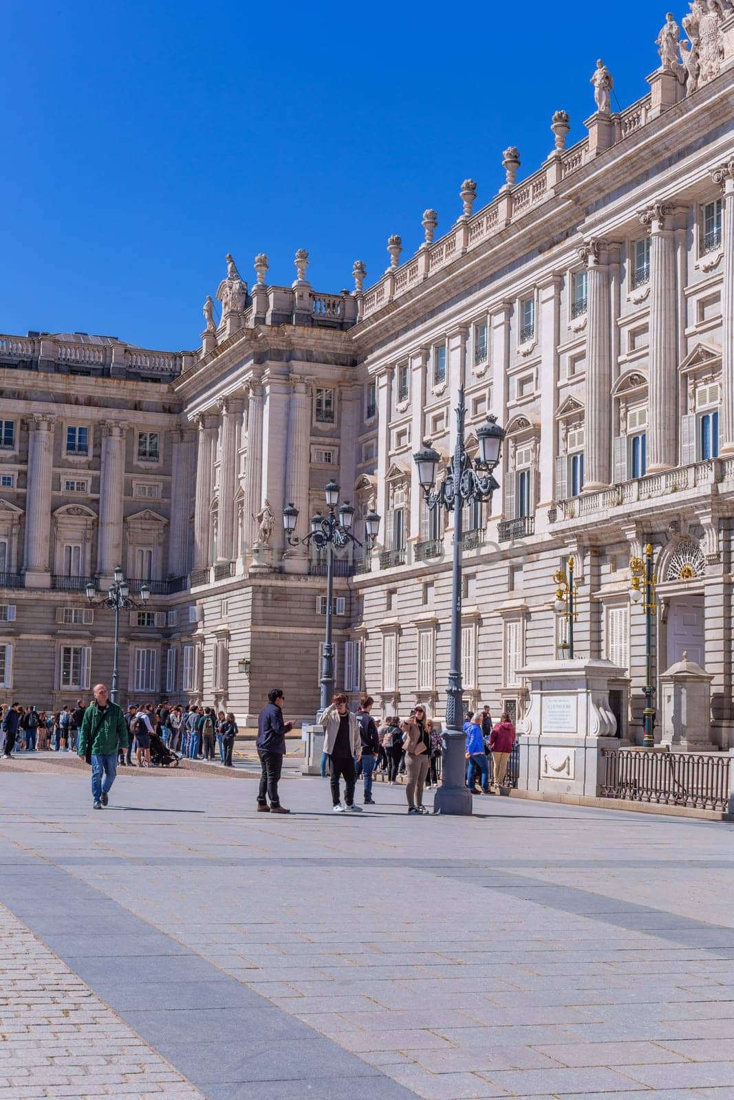 Madrid, Spain: April 24, 2024: Tourists at the Royal Palace in Madrid, Spain. Royal Palace of Madrid - is official residence of Spanish Royal Family. Madrid, Spain
