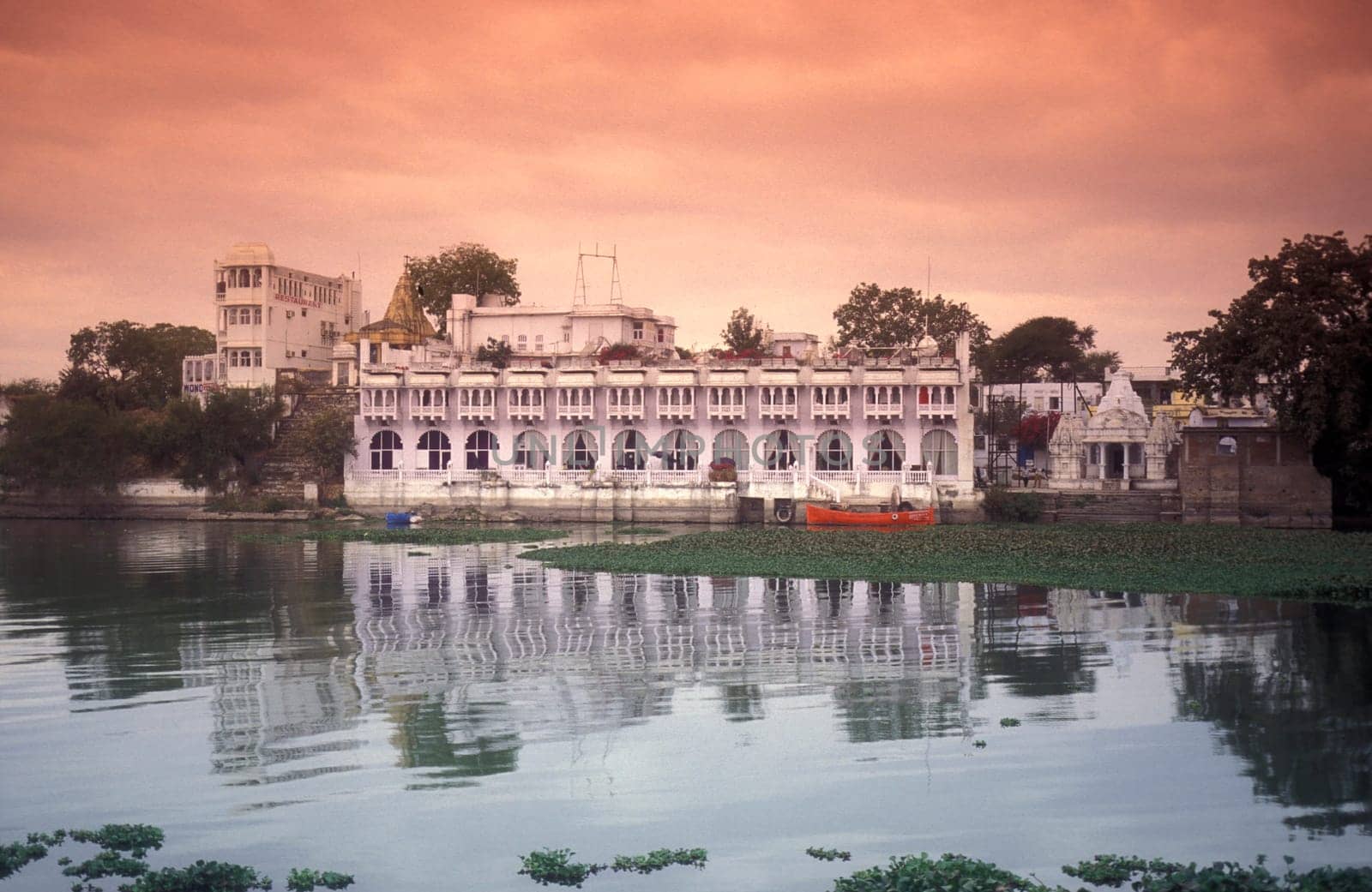 Architectur with Palace and Houses on the Pichhola Lake in the Town of Udaipur in the Province of Rajasthan in India.  India, Udaipur, January, 1998