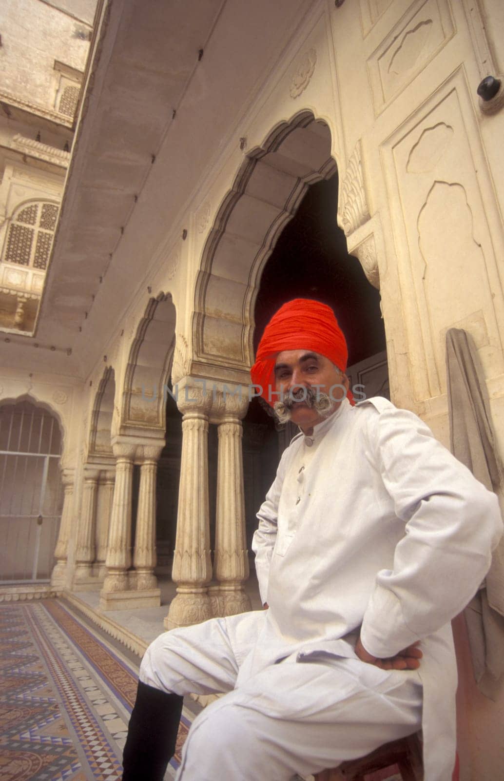 a Rajasthani men in traditional dress at the City Palace Hotel in the Town of Udaipur in the Province of Rajasthan in India.  India, Udaipur, January, 1998
