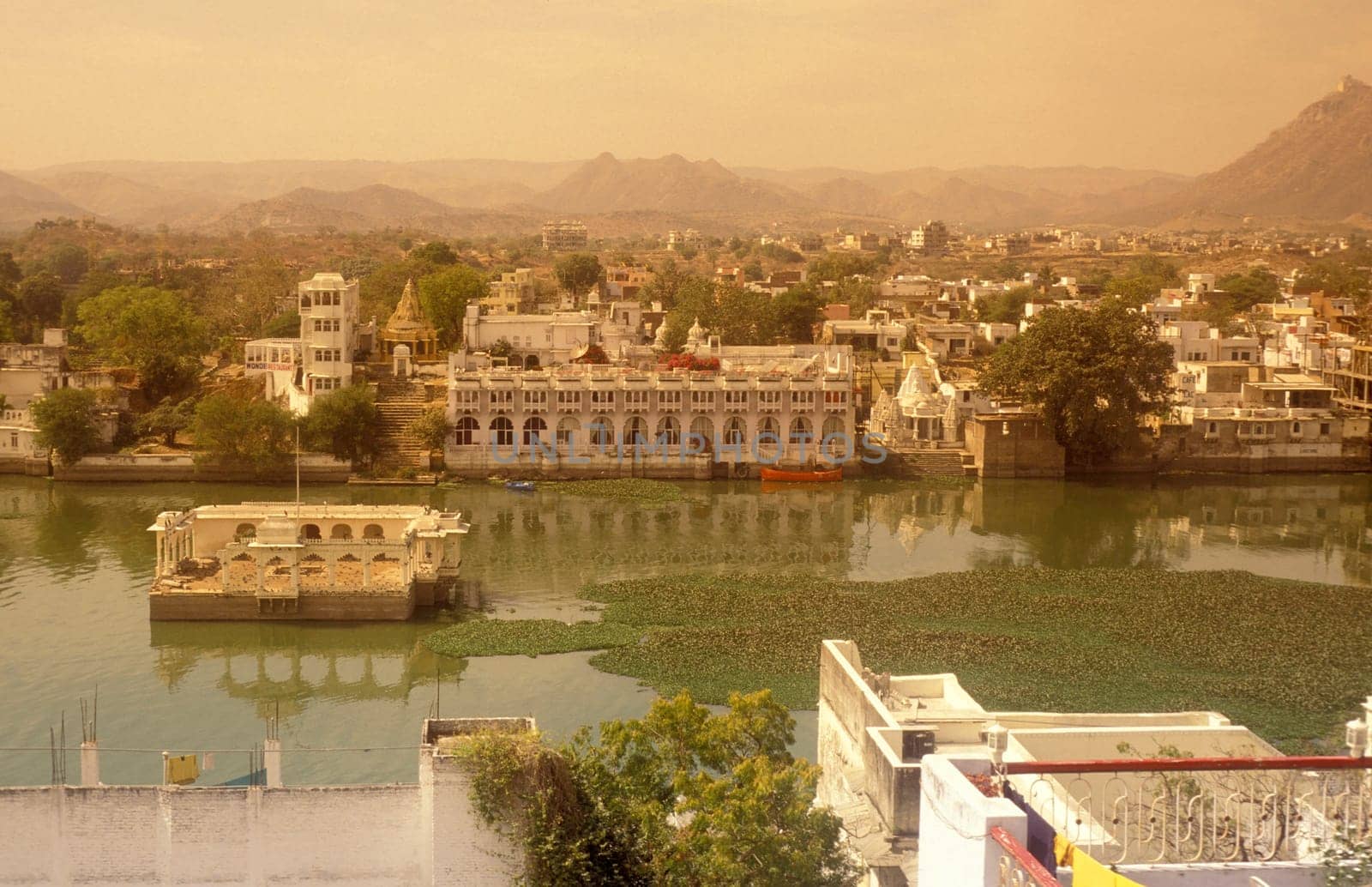 Architectur with Palace and Houses on the Pichhola Lake in the Town of Udaipur in the Province of Rajasthan in India.  India, Udaipur, January, 1998