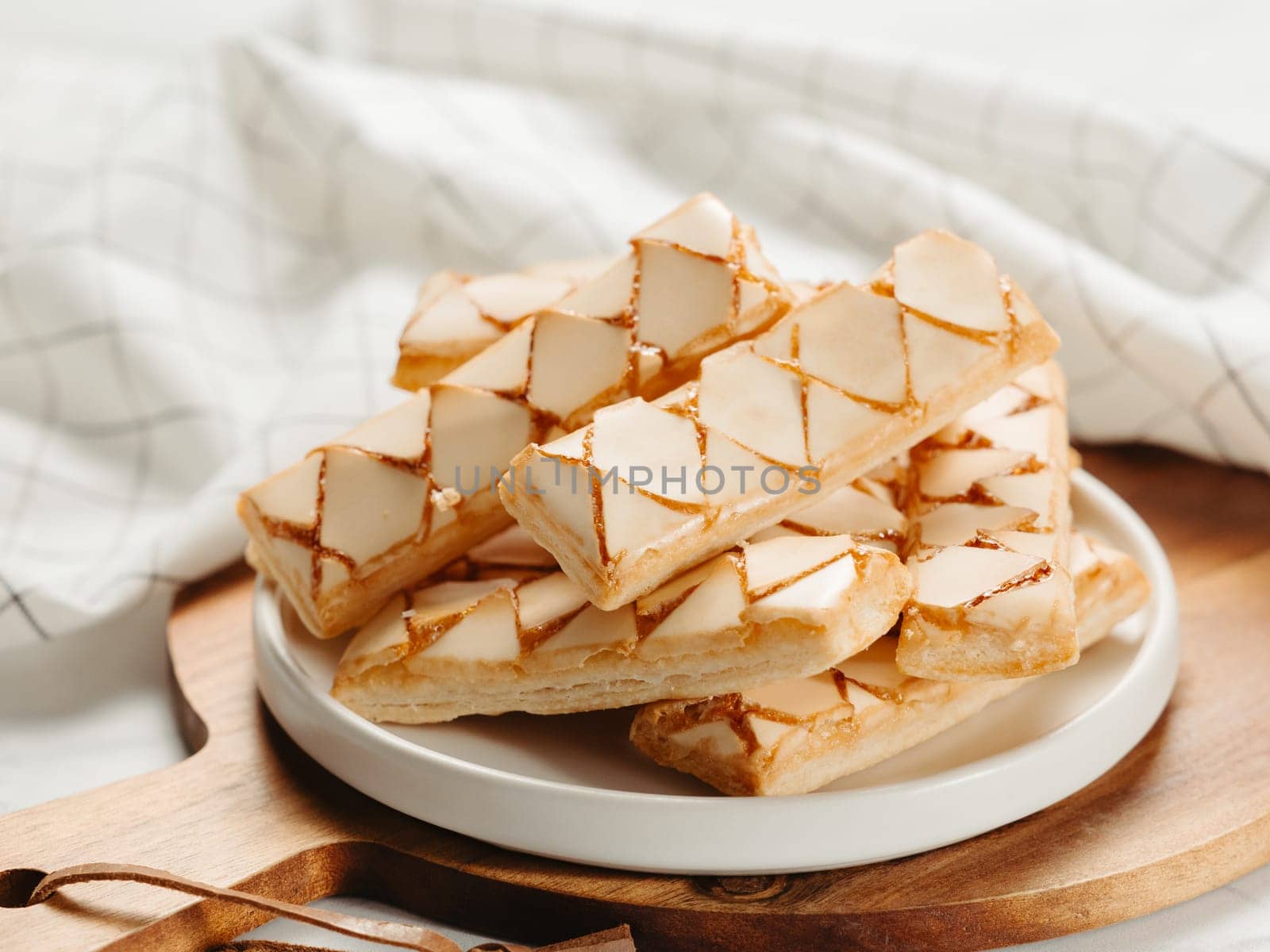 Italian crispy sweet bakery Sfogliatine glassate over white marble table surface. Tasty breakfast with apricot glaze puff pastries.