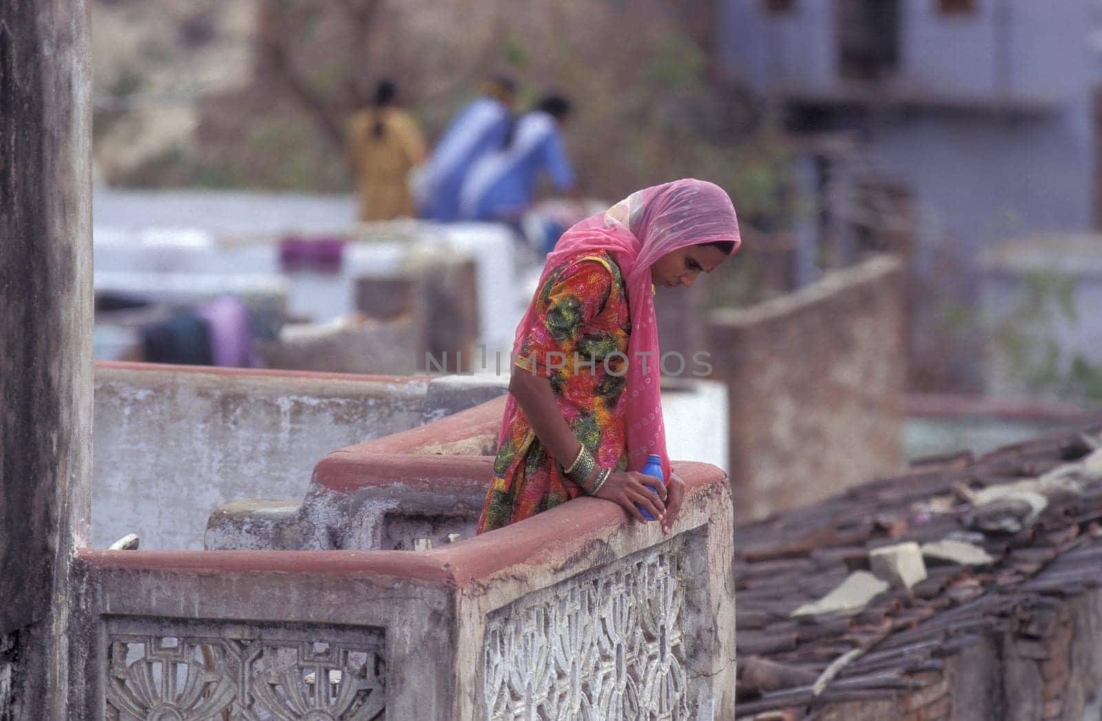 a Women stay at her Home and Balcony in the old Town at Jaisalmer Fort in city of Jaisalmer at  Province of Rajasthan in India.  India, Jaisalmer, January, 1998