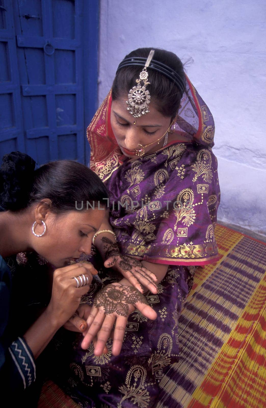 a Rajasthani women is making a Henna Hand painting in the Town of Jaisalmer in the Province of Rajasthan in India.  India, Jaisalmer, January, 1998