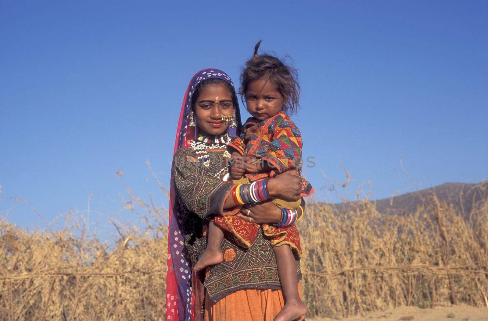a portrait of a Rajasthani women with her Baby in the Town of Jaisalmer in the Province of Rajasthan in India.  India, Jaisalmer, January, 1998