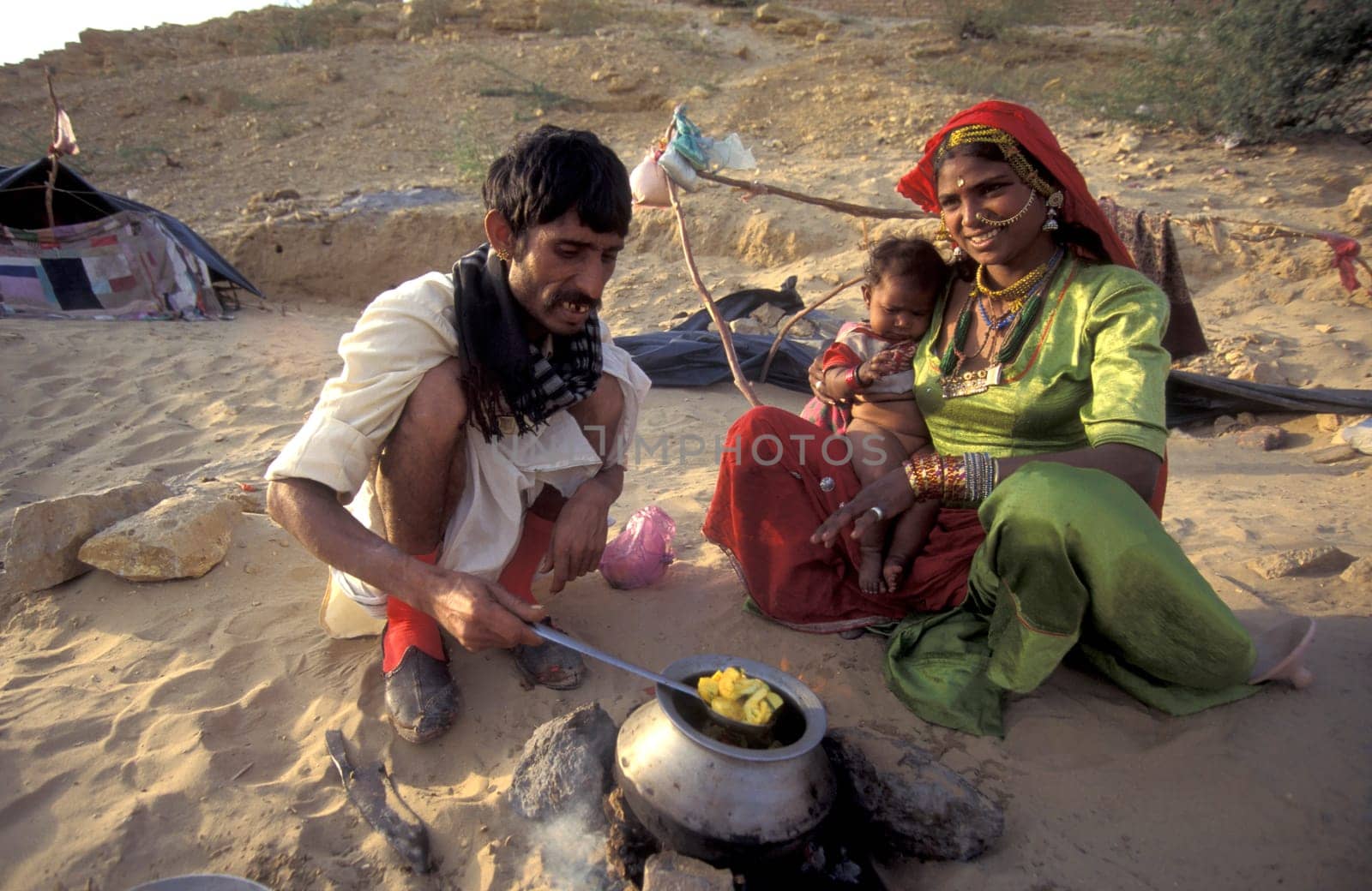 a Rajasthani Family is cocking on a fire with her Baby in the Town of Jaisalmer in the Province of Rajasthan in India.  India, Jaisalmer, January, 1998