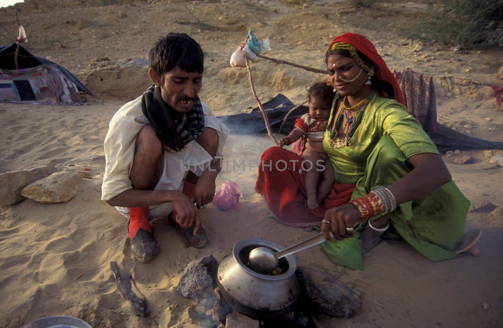 a Rajasthani Family is cocking on a fire with her Baby in the Town of Jaisalmer in the Province of Rajasthan in India.  India, Jaisalmer, January, 1998
