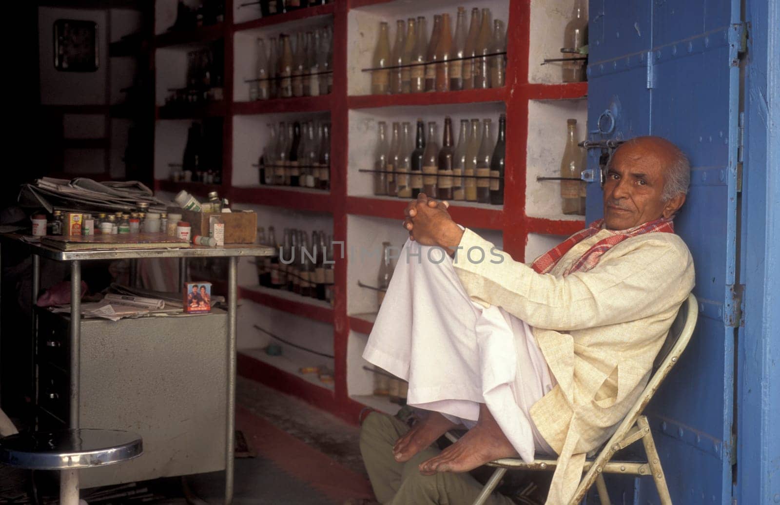 A Indian Doctor at his Drugstore and Madicine Shop at a market in the Town of Jaisalmer in the Province of Rajasthan in India.  India, Jaisalmer, January, 1998
