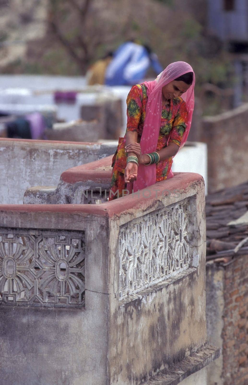 a Women stay at her Home and Balcony in the old Town at Jaisalmer Fort in city of Jaisalmer at  Province of Rajasthan in India.  India, Jaisalmer, January, 1998