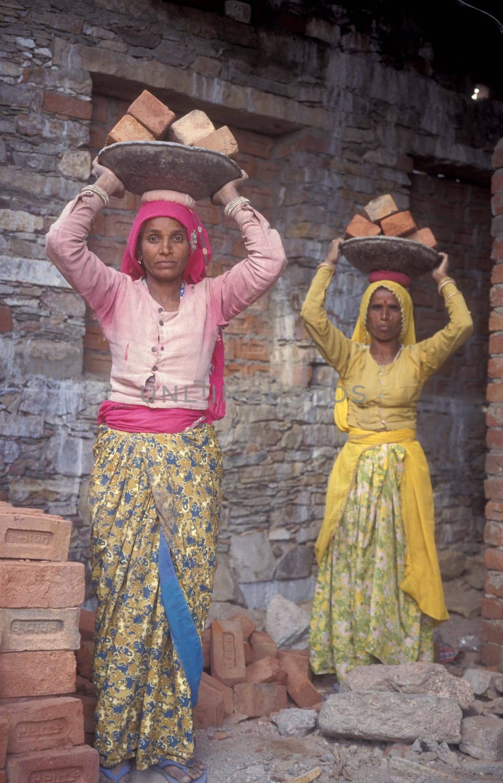 two Rajasthani women at a construction work in the Town of Jaisalmer in the Province of Rajasthan in India.  India, Jaisalmer, January, 1998
