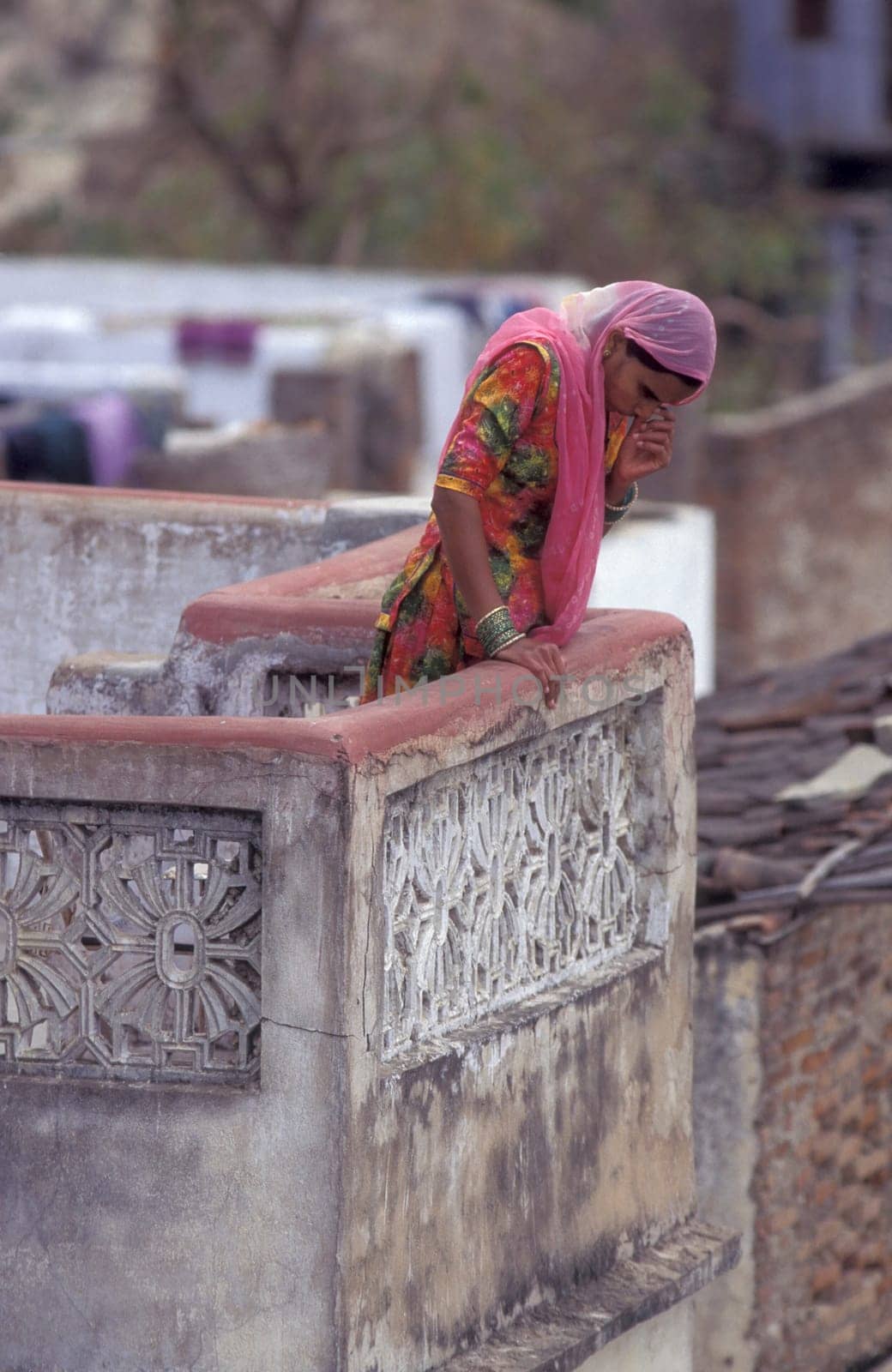 a Women stay at her Home and Balcony in the old Town at Jaisalmer Fort in city of Jaisalmer at  Province of Rajasthan in India.  India, Jaisalmer, January, 1998