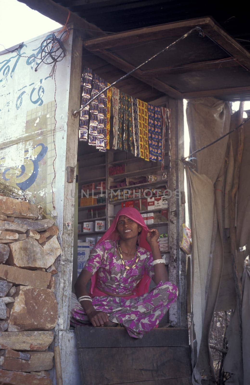 a Rajasthani women at a shop in the Town of Jaisalmer in the Province of Rajasthan in India.  India, Jaisalmer, January, 1998