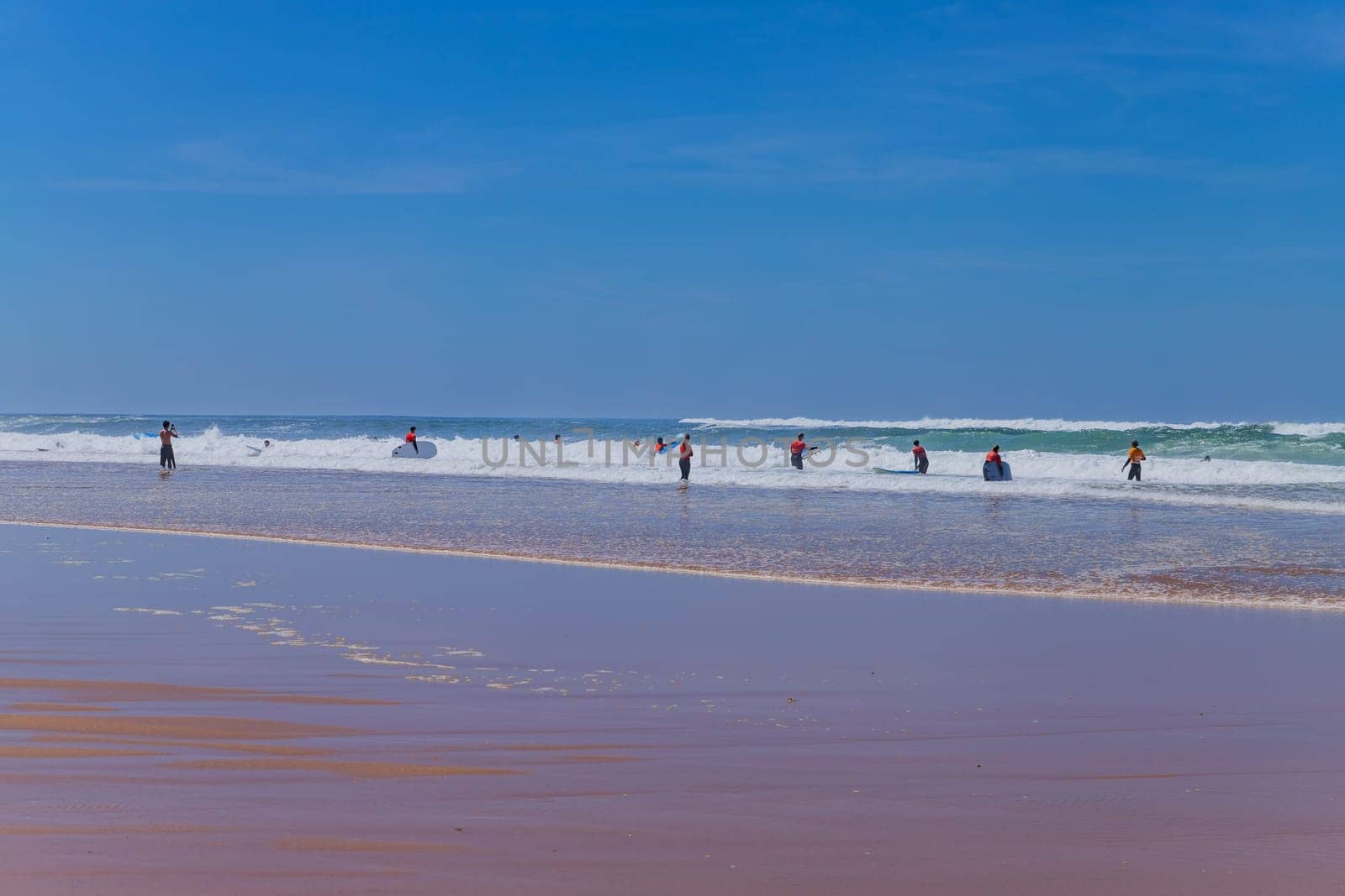 Ericeira, Portugal: April 13, 2024: Group of surfers with surfboards going to surfing. Ericeira is the famous surfing destination in Portugal.