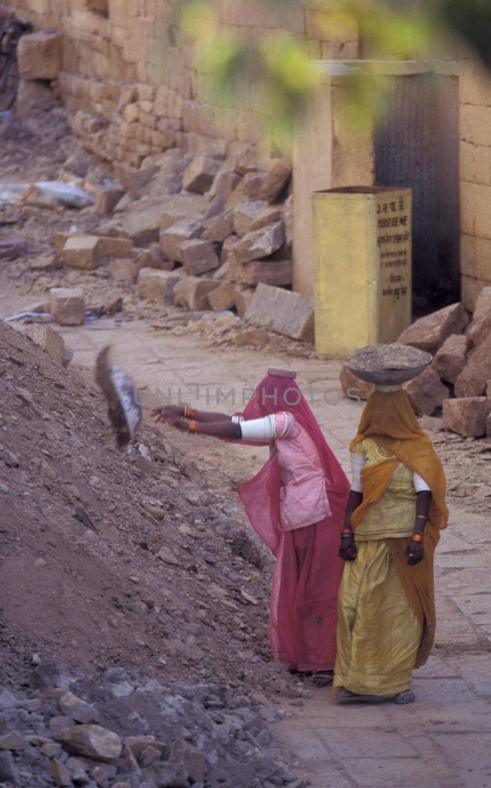 two Rajasthani women at a construction work in the Town of Jaisalmer in the Province of Rajasthan in India.  India, Jaisalmer, January, 1998