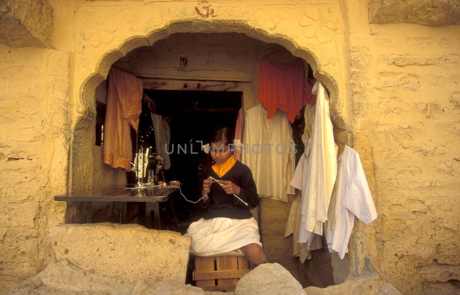 a young Rajasthani women at a Tailor shop in the Town of Jaisalmer in the Province of Rajasthan in India.  India, Jaisalmer, January, 1998