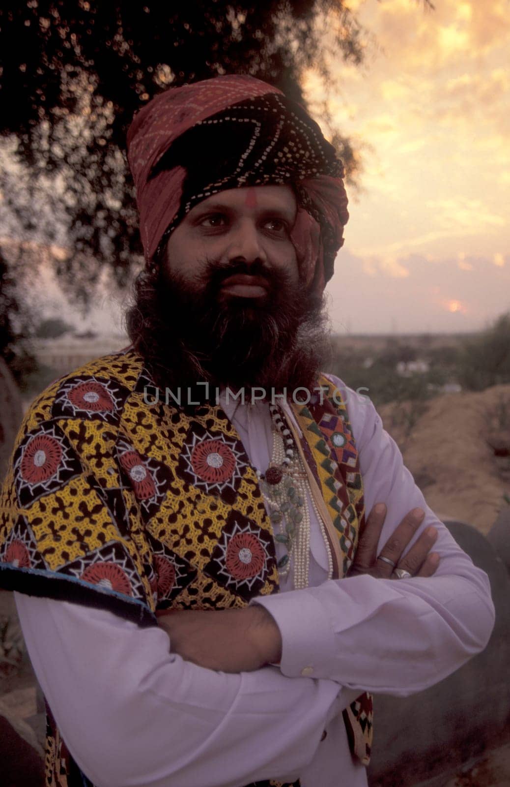 a camel herder in traditional Rajasthani dress at the Bikaner Camel Festival in the Town of Bikaner in the Province of Rajasthan in India.  India, Bikaner, January, 1998