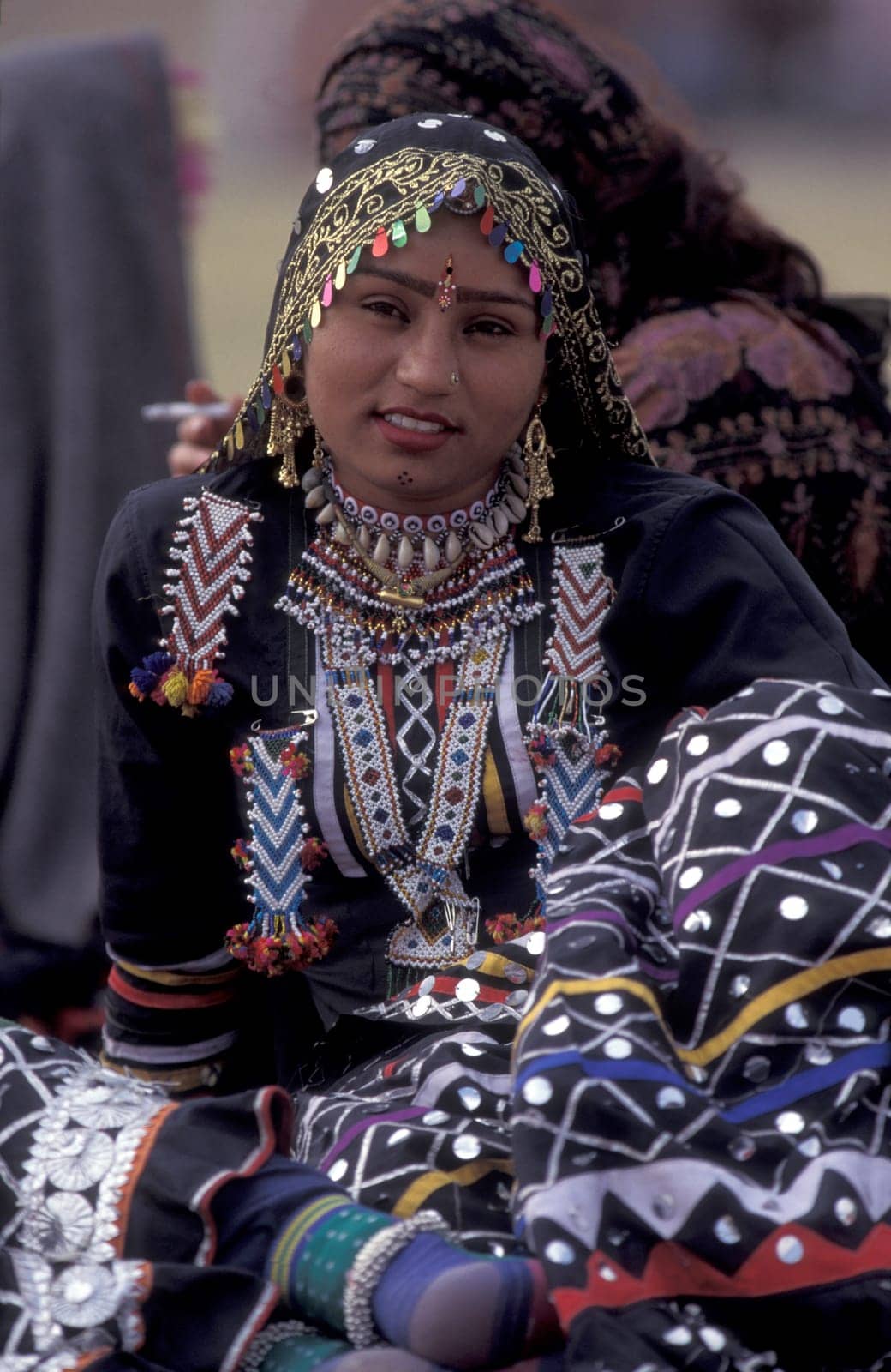 Women in traditional Rajasthani dress at the Bikaner Camel Festival in the Town of Bikaner in the Province of Rajasthan in India.  India, Bikaner, January, 1998