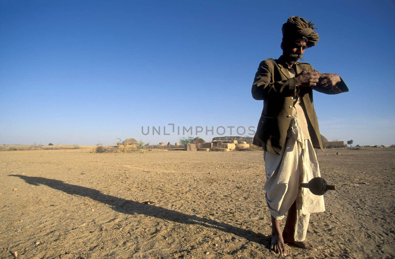 A old Men work with a Cord Spindle in a small Village near the Town of Bikaner in the Desert Thar in the Province of Rajasthan in India.  India, Bikaner, January, 1998