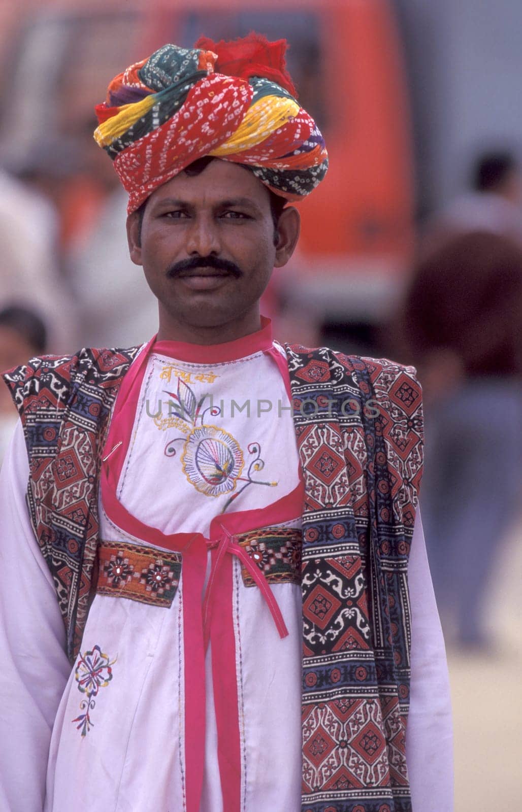 a camel herder in traditional Rajasthani dress at the Bikaner Camel Festival in the Town of Bikaner in the Province of Rajasthan in India.  India, Bikaner, January, 1998