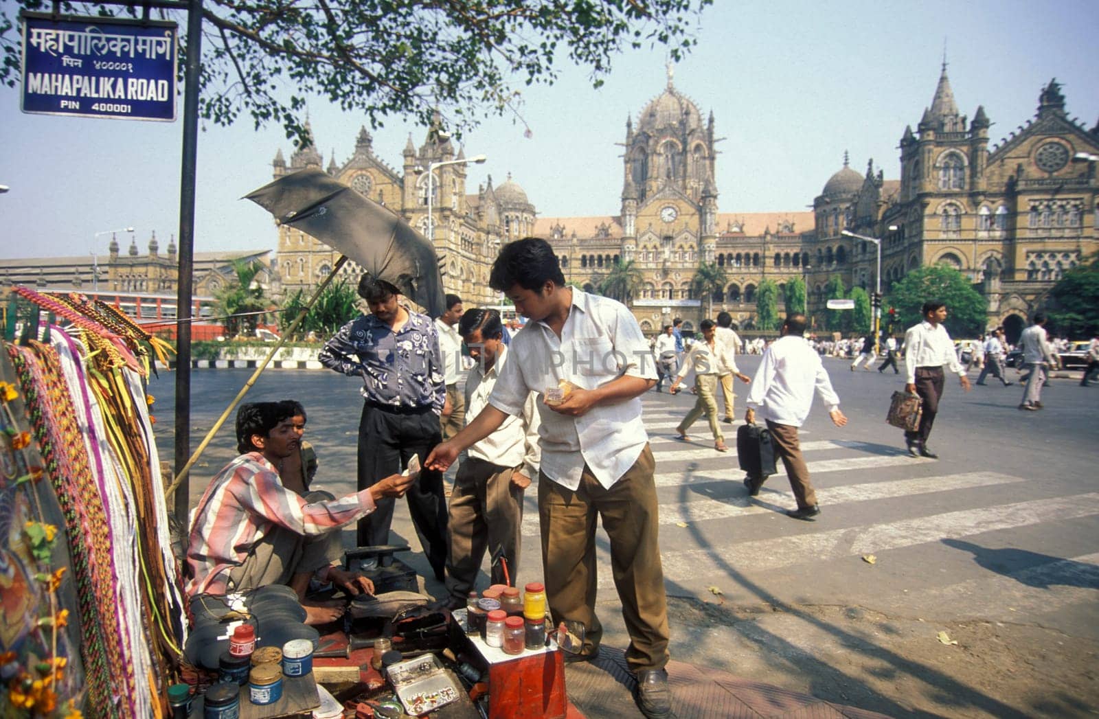People and Market in front of the architecture of the Mumbai Railway Station or Chhatrapati Shivaji Terminus in the city centre of Mumbai in India.  India, Mumbai, March, 1998
