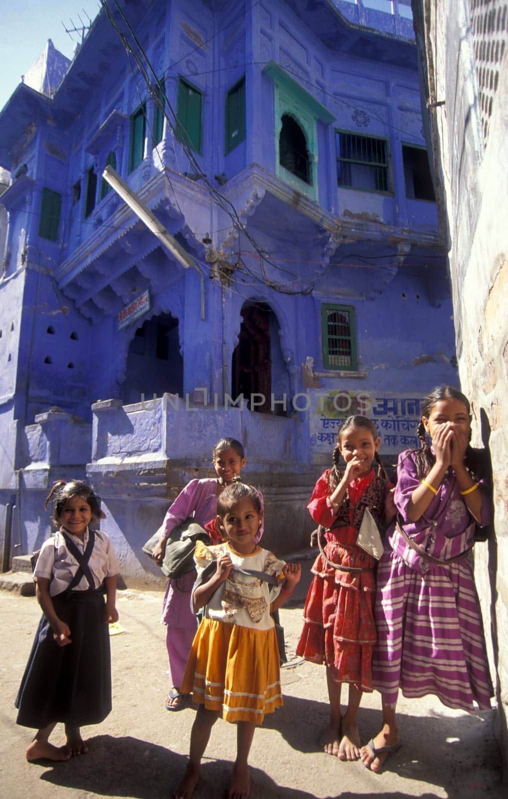 children at a blue painted living House in the Blue City and Town of Jodhpur in the Province of Rajasthan in India.  India, Jodhpur, January, 1998