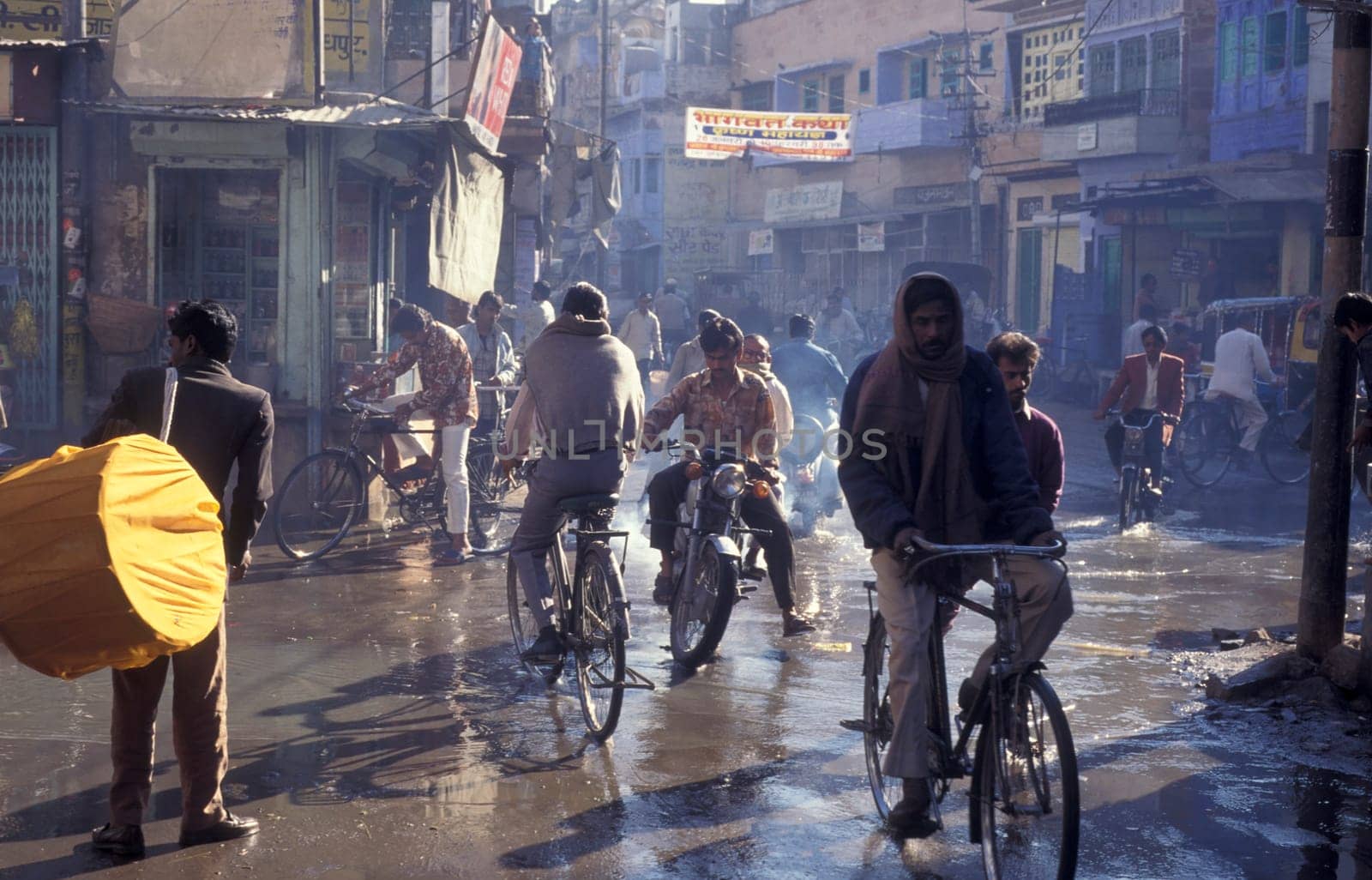 the Traffic with Motorbike and Bicycle in the Blue City and Town of Jodhpur in the Province of Rajasthan in India.  India, Jodhpur, January, 1998