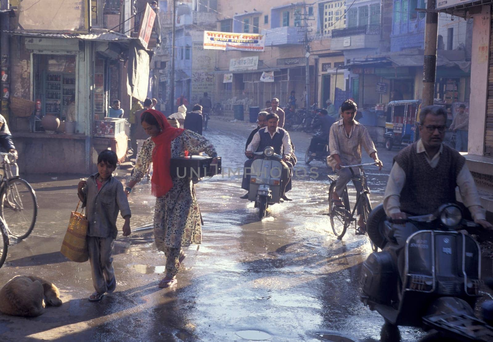 the Traffic with Motorbike and Bicycle in the Blue City and Town of Jodhpur in the Province of Rajasthan in India.  India, Jodhpur, January, 1998