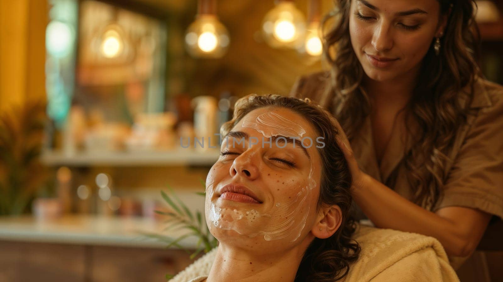 Cosmetologist doing facial massage in a spa to a client