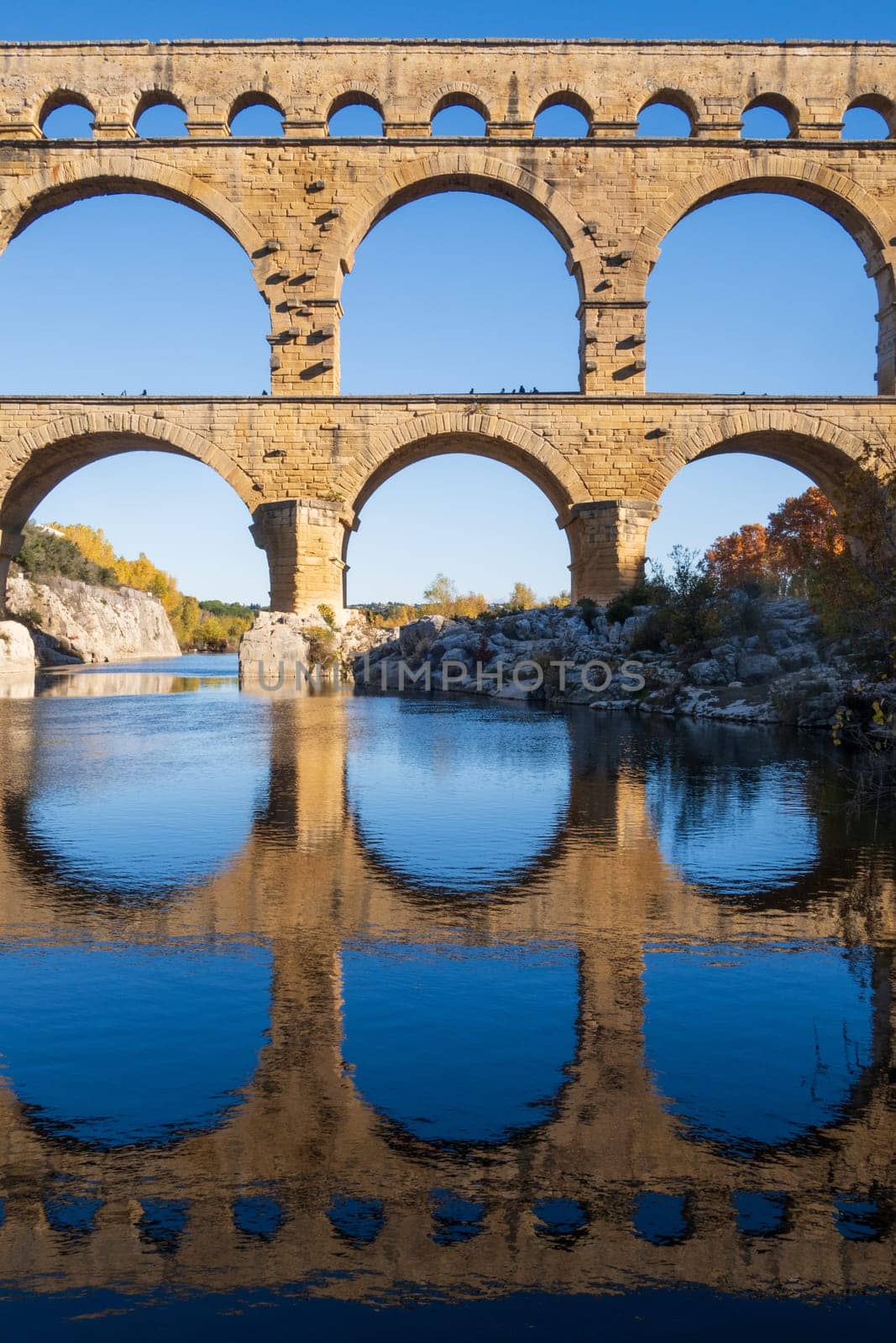 The Pont du Gard over Gardon river. Ancient Roman three-tiered aqueduct bridge. Vertcal photography taken in Vers-Pont-du-Gard, Provence, southern France