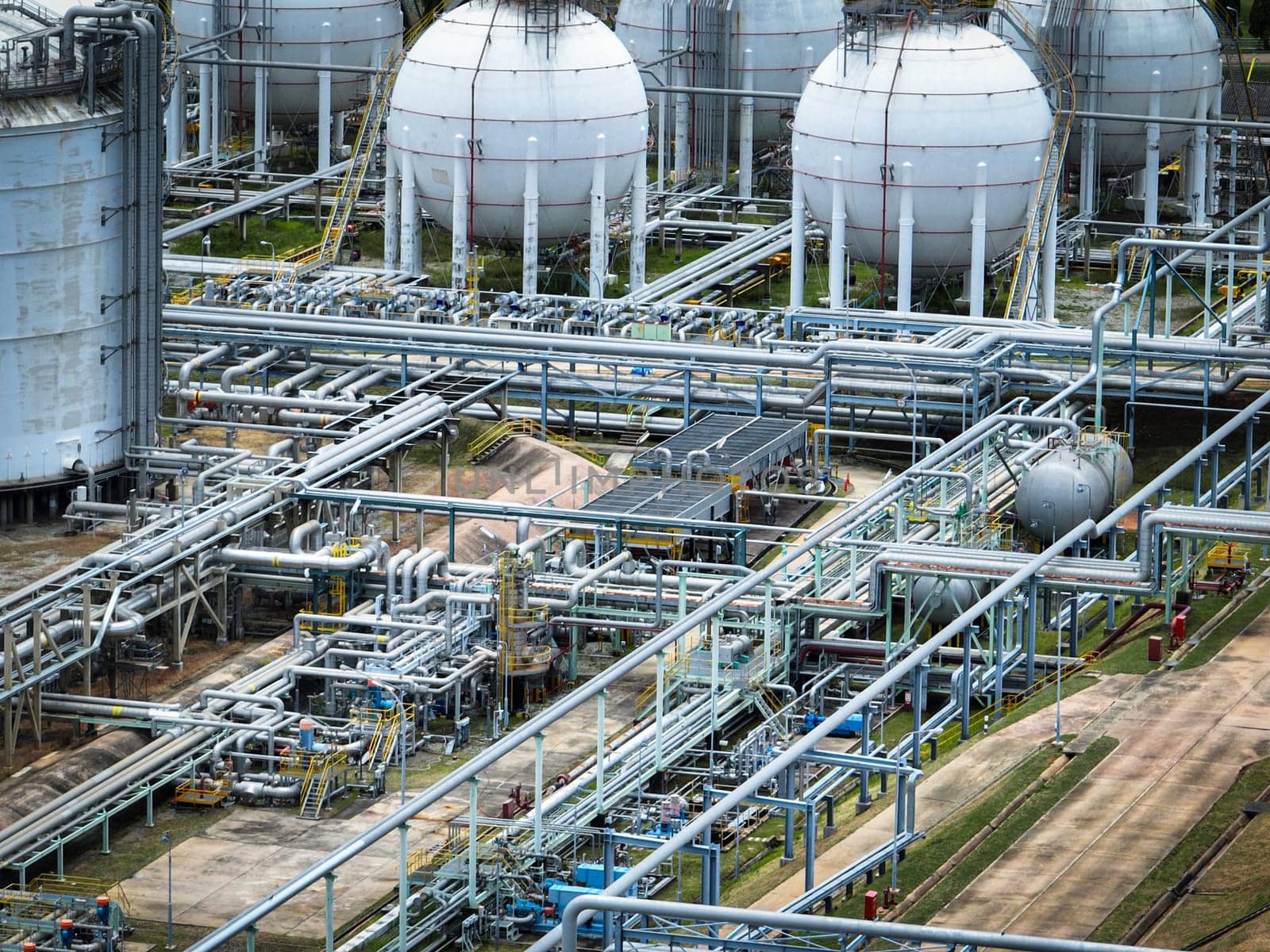 Industrial oil refinery and petrochemical plant with extensive steel pipelines and gas storage tanks. Infrastructure for the energy and fuel. Oil and gas refinery plant. Network of pipes and tanks.