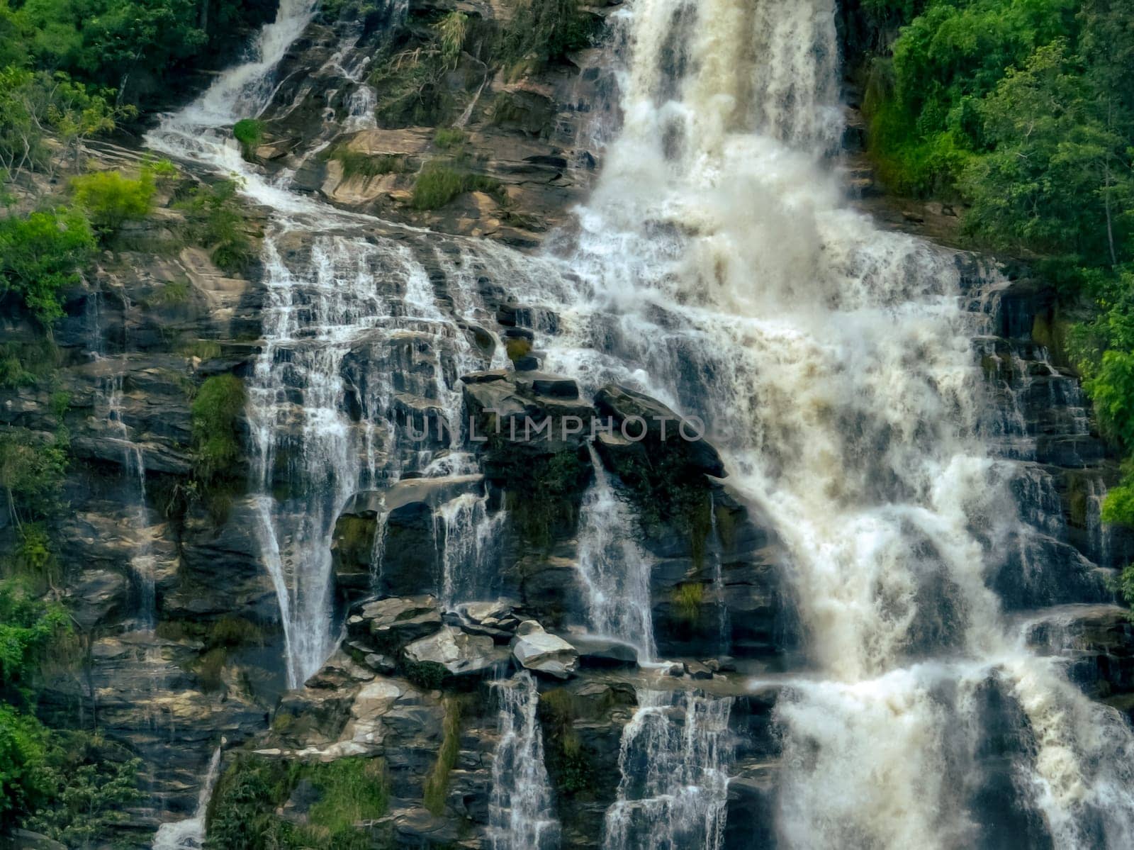 Aerial view of a waterfall in a lush tropical green forest in Doi Inthanon National Park, Chiang Mai, Thailand. This nature landscape showcases water sustainability and scenic travel destinations.