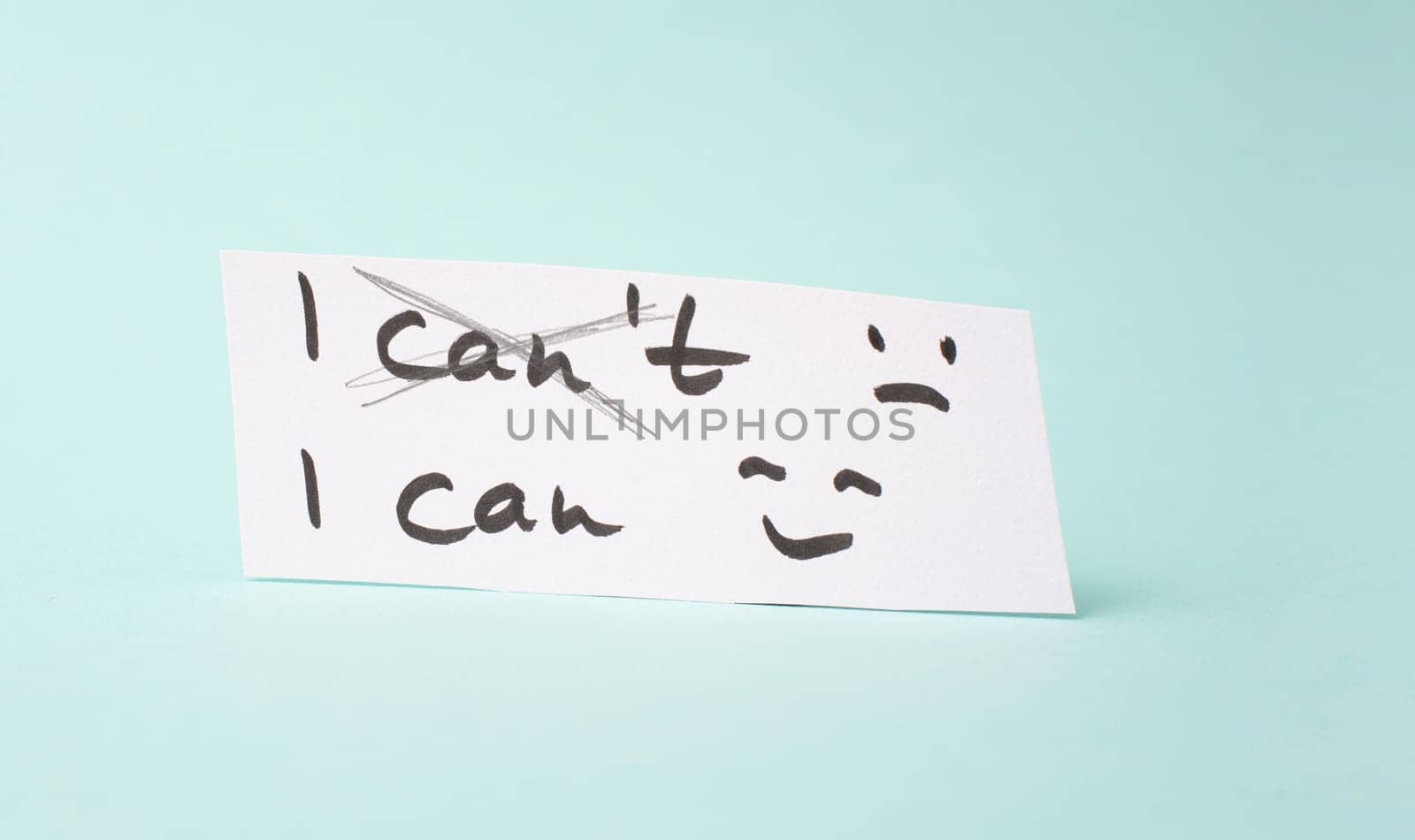 The word can not is standing on a paper, having a goal, postive thinking, be an optimist, do it, self confident, happy and sad face