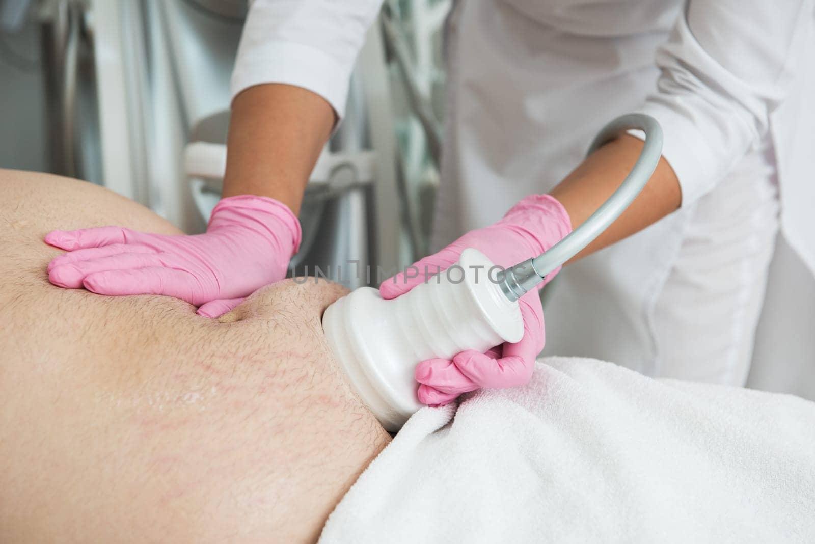 Closeup photo of fat man with big belly having cavitation procedure removing cellulite on abdomen in modern beauty clinic