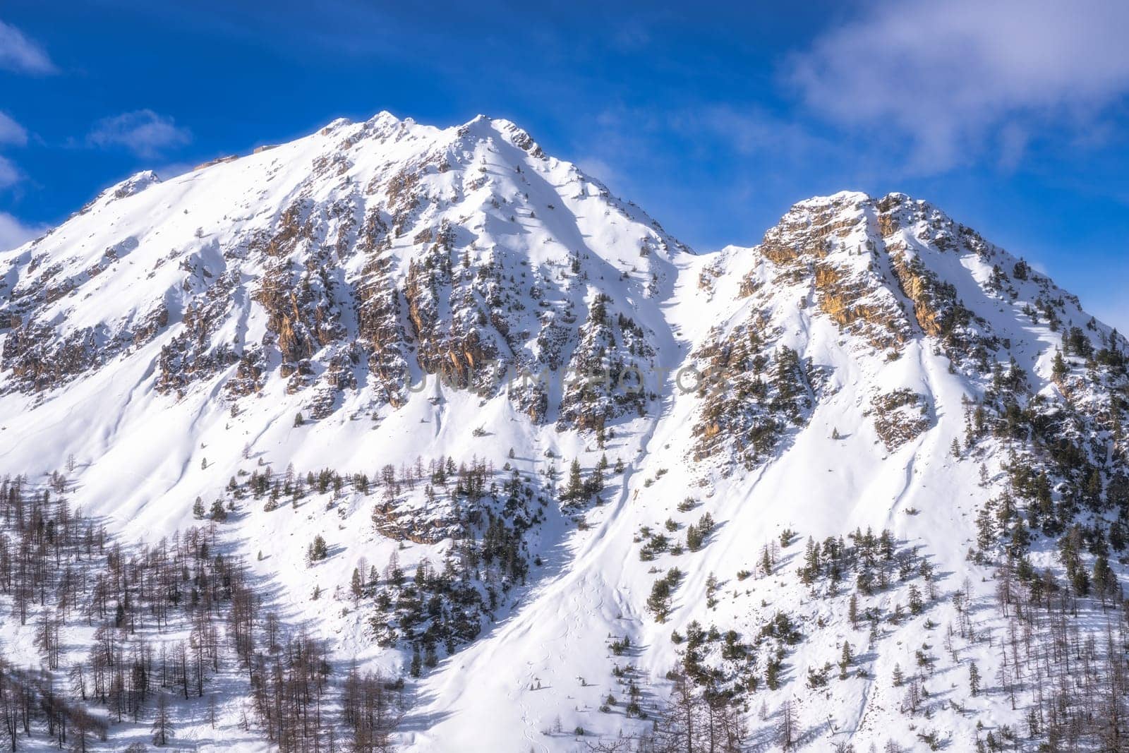 Two beautiful, snow covered mountain peaks. Winter sport in Alps. Montgenevre ski village on a border of France and Italy