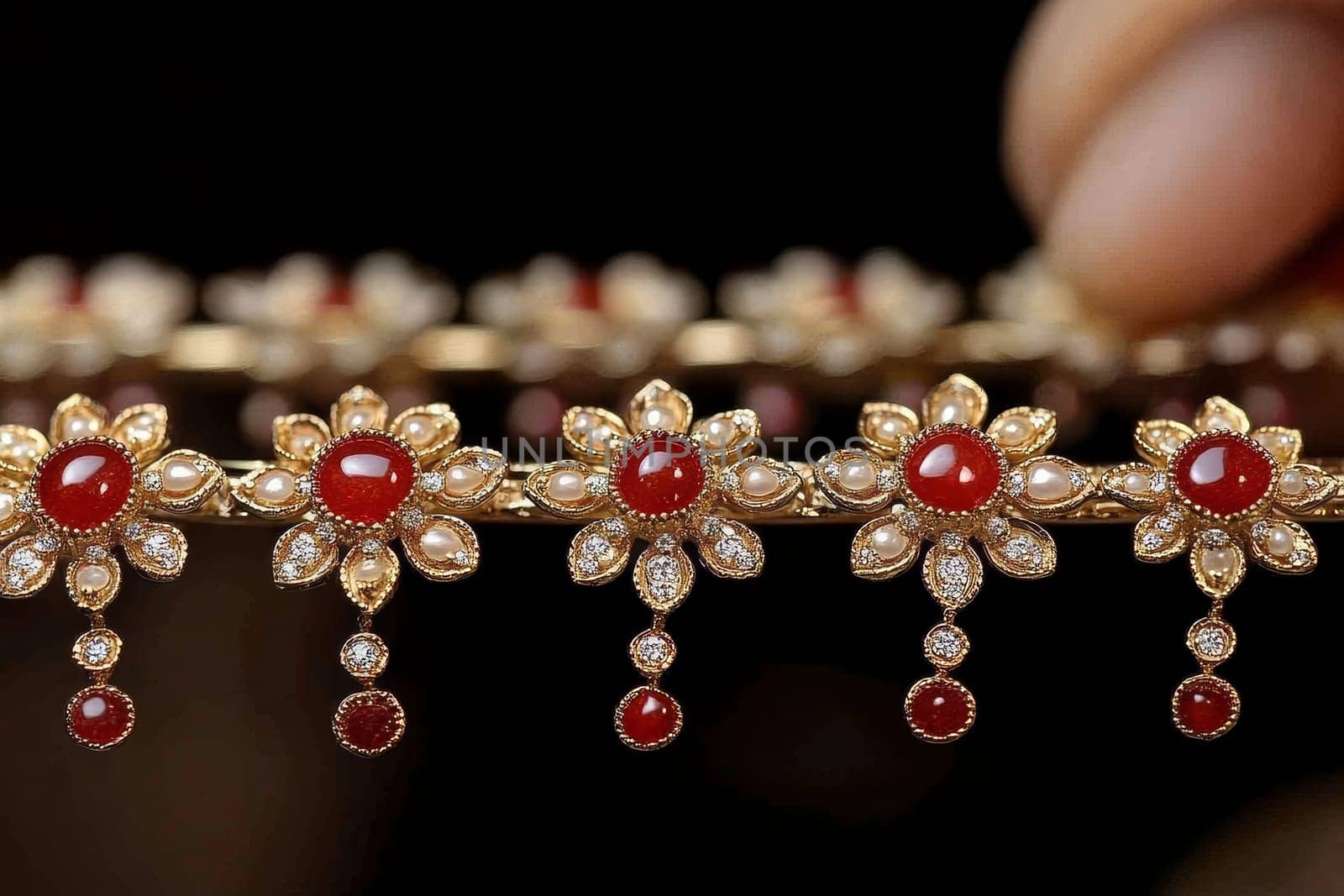 Luxurious gold jewelry set with rubies and pearls, featuring intricate floral designs and dangling elements.
