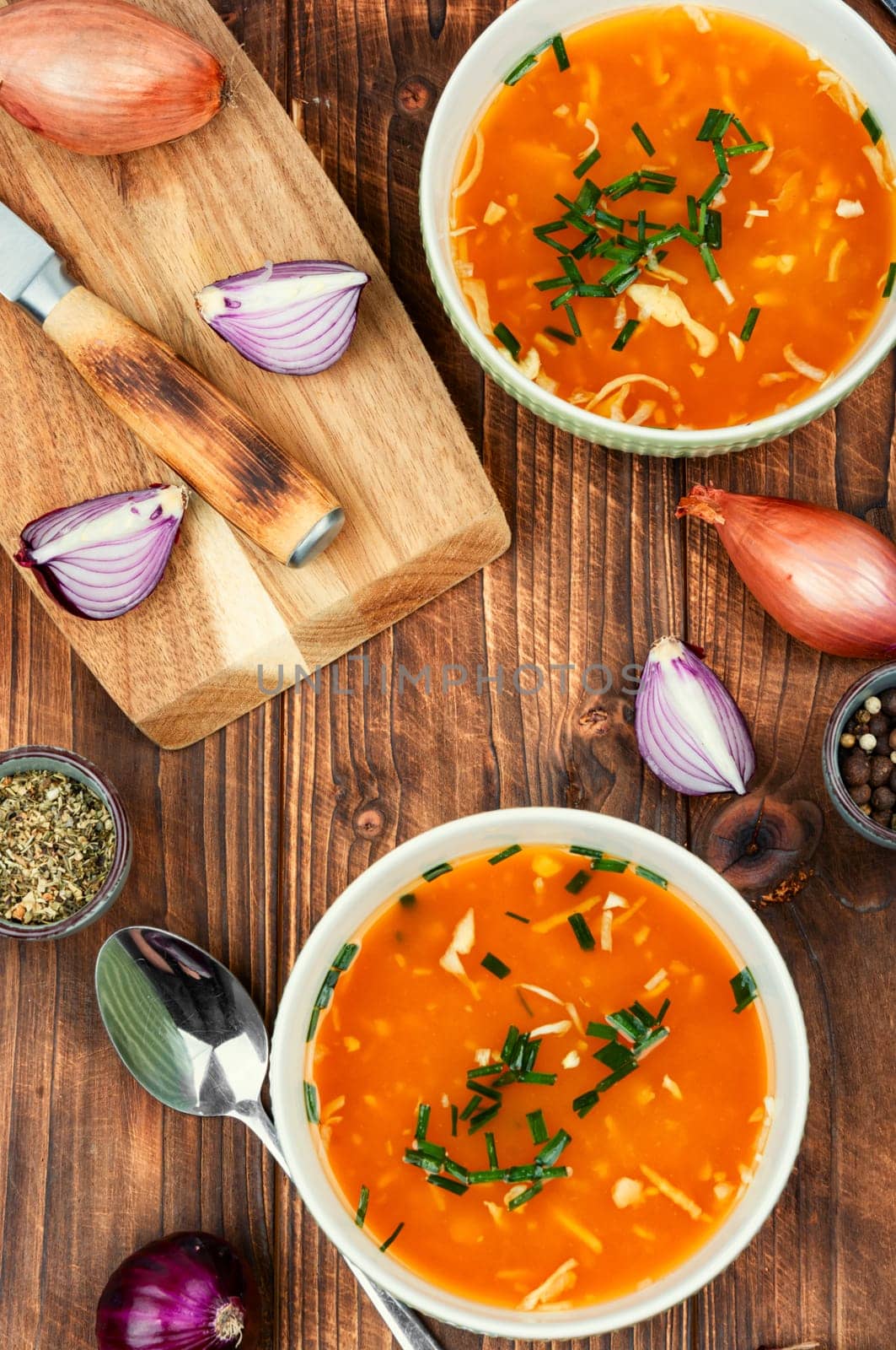 Fragrant onion soup in a ceramic bowl on a rustic wooden table.