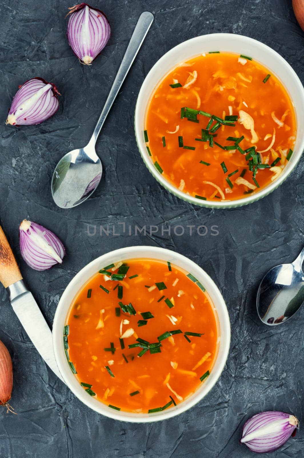 Fragrant onion soup in a ceramic bowl on a rustic wooden table.