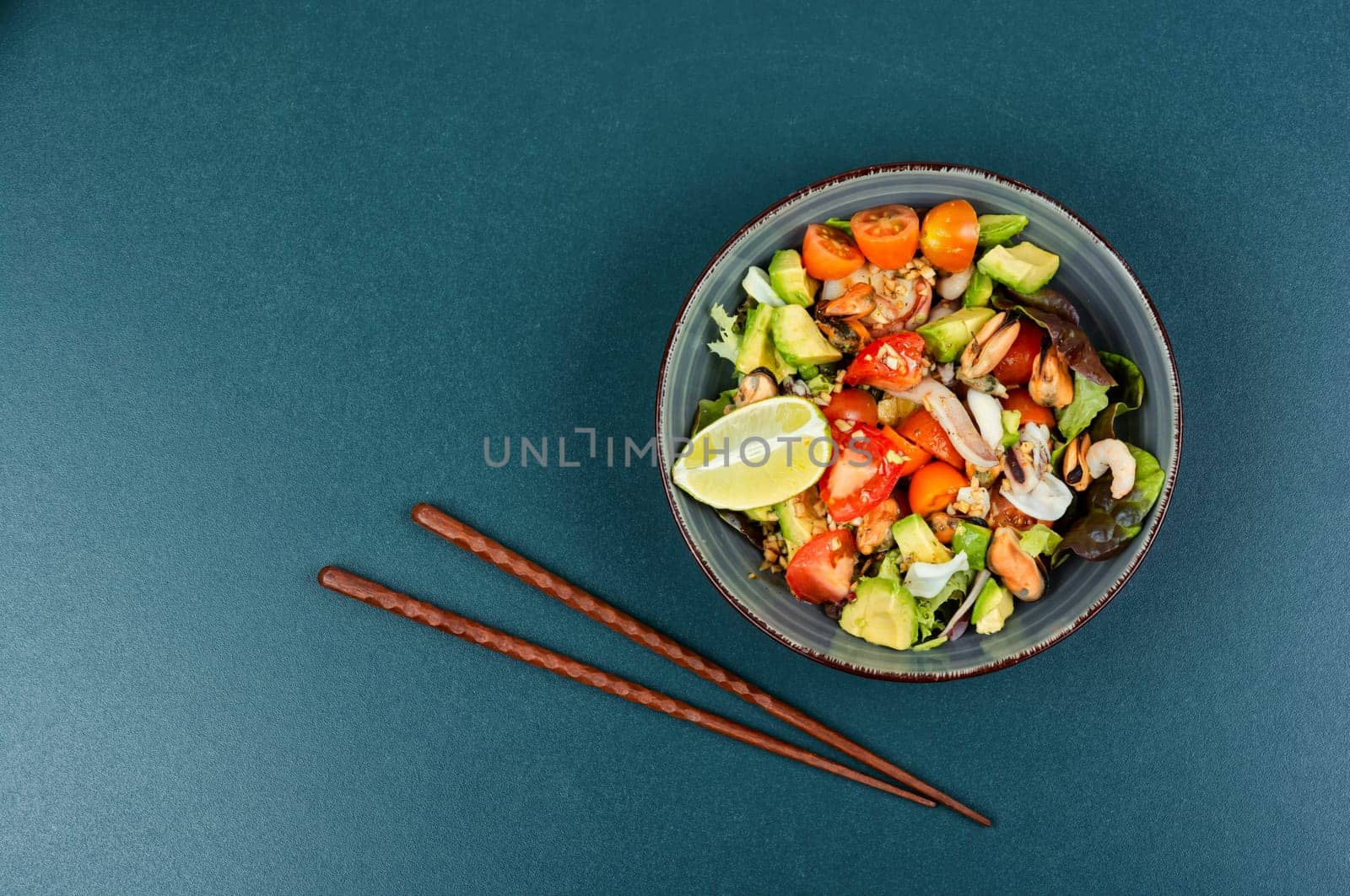 Salad with calamari, shrimp, clams and fresh vegetables. Copy space.