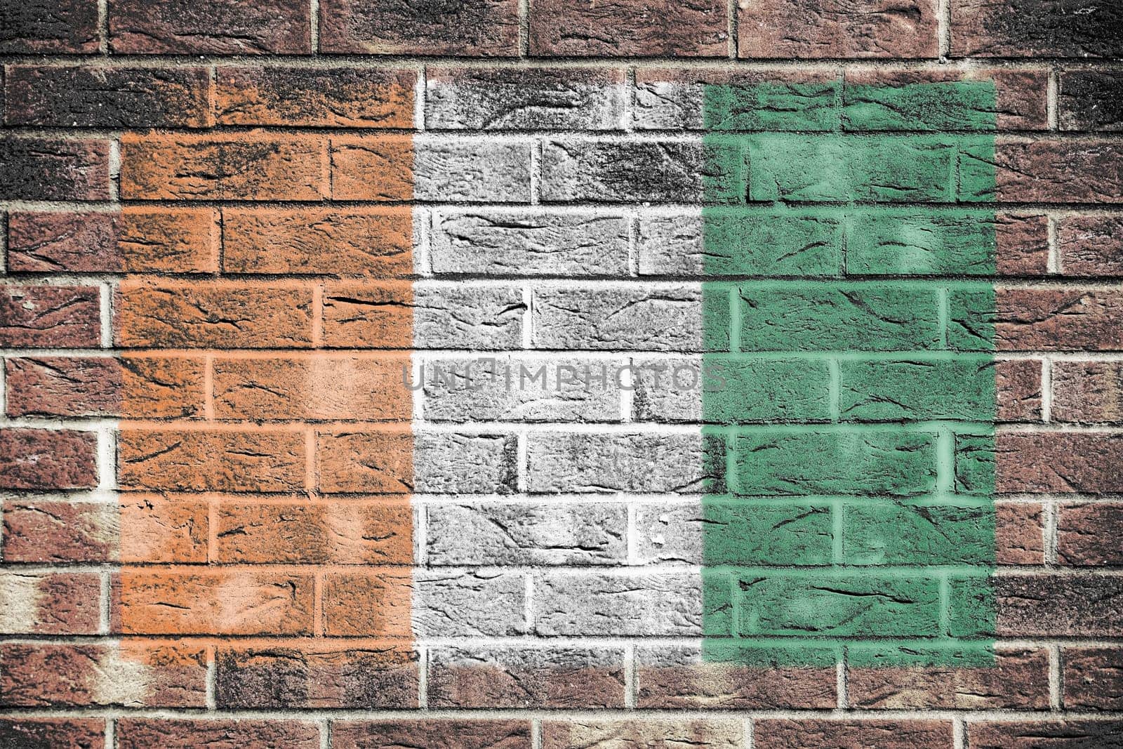 An Ivory Coast Cote DIvoire flag on an old brick wall background