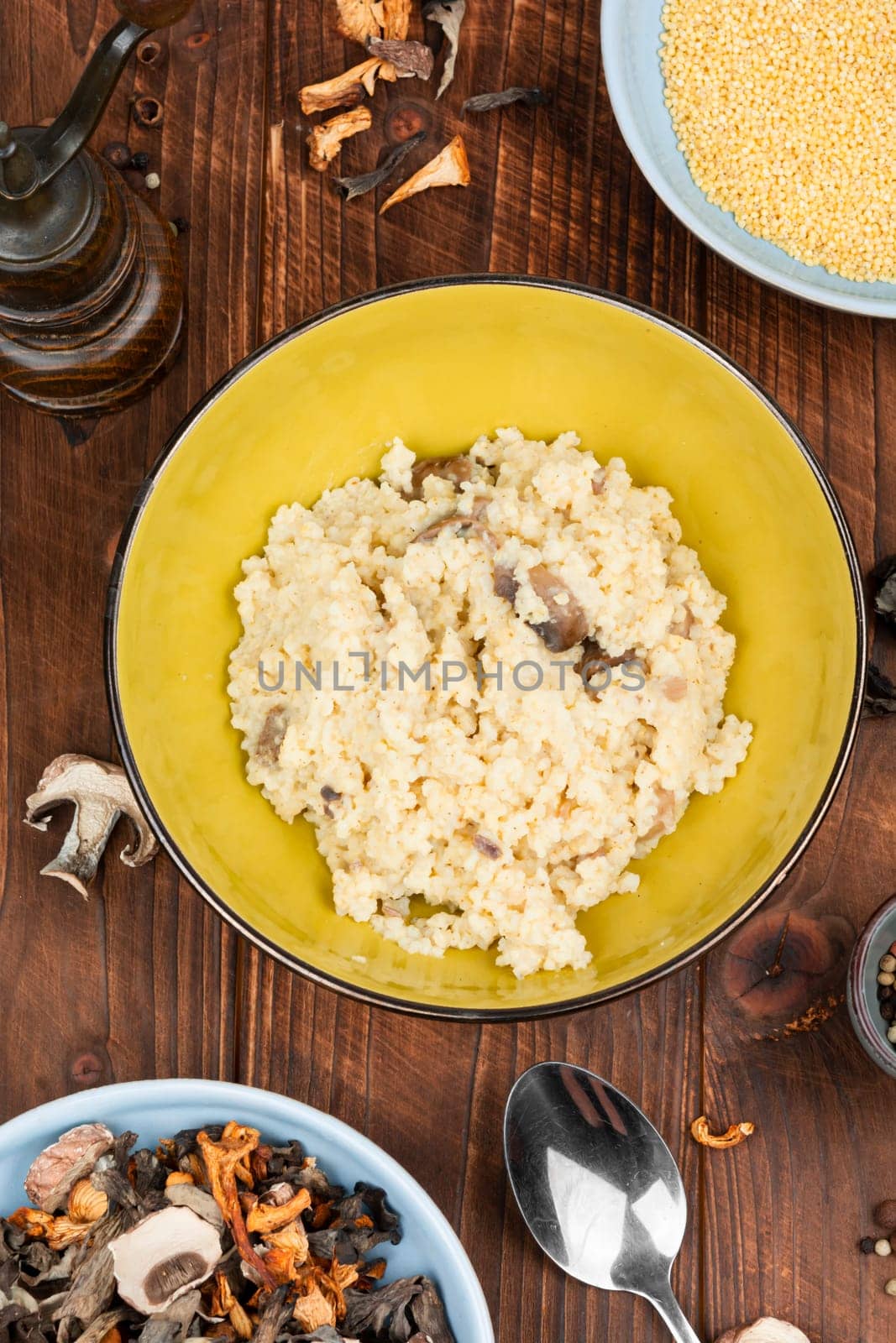 Millet porridge with mushrooms in a bowl on a rustic wooden background. Healthy food.