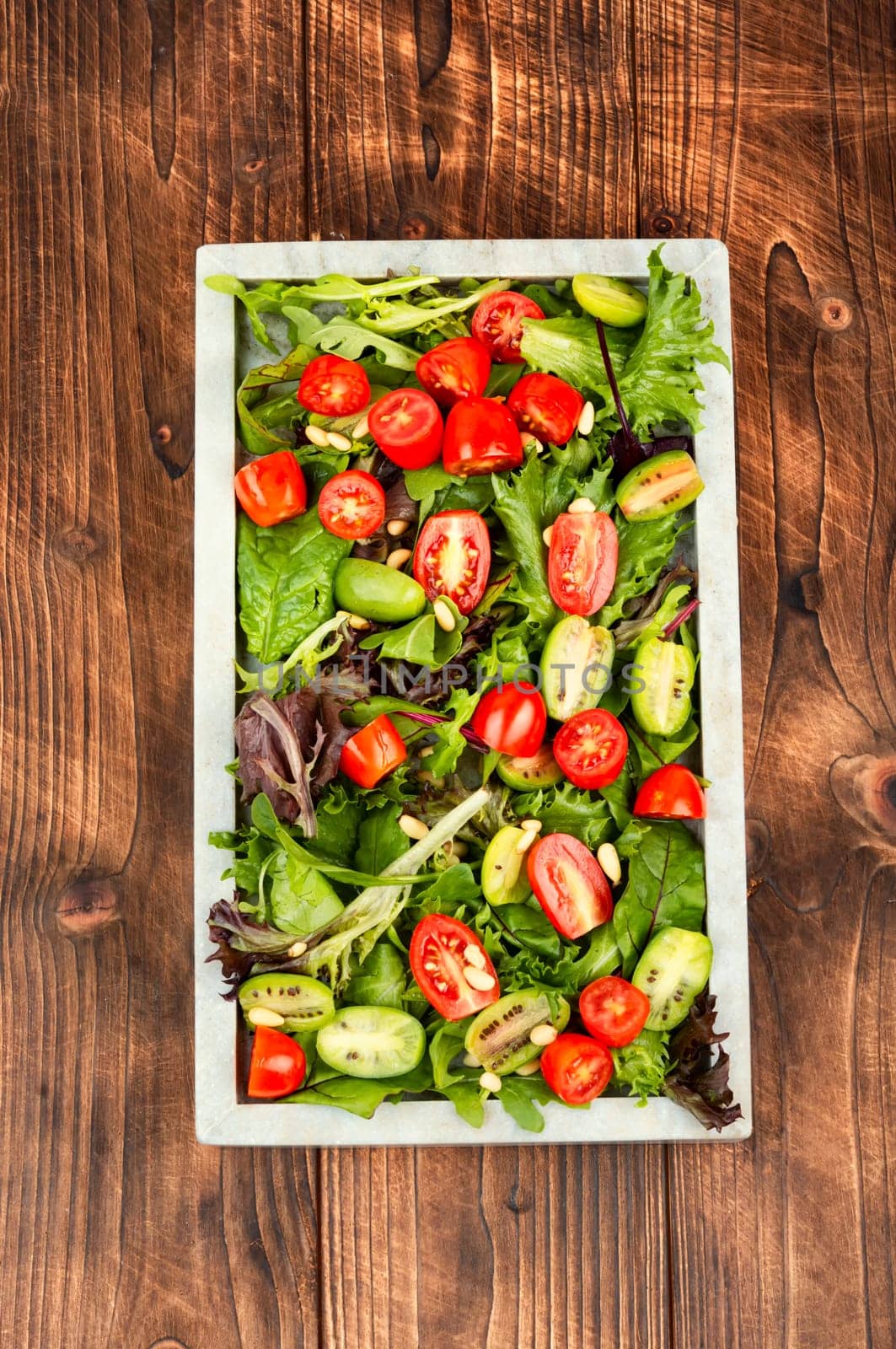 Tasty salad with tomatoes, different lettuce and pine nuts. Concept for a healthy food. Free space for your text.