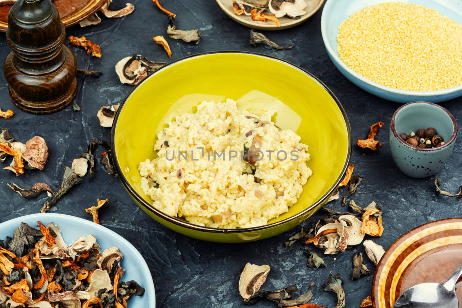 Millet porridge with mushrooms in a bowl on a rustic wooden background. Healthy food.