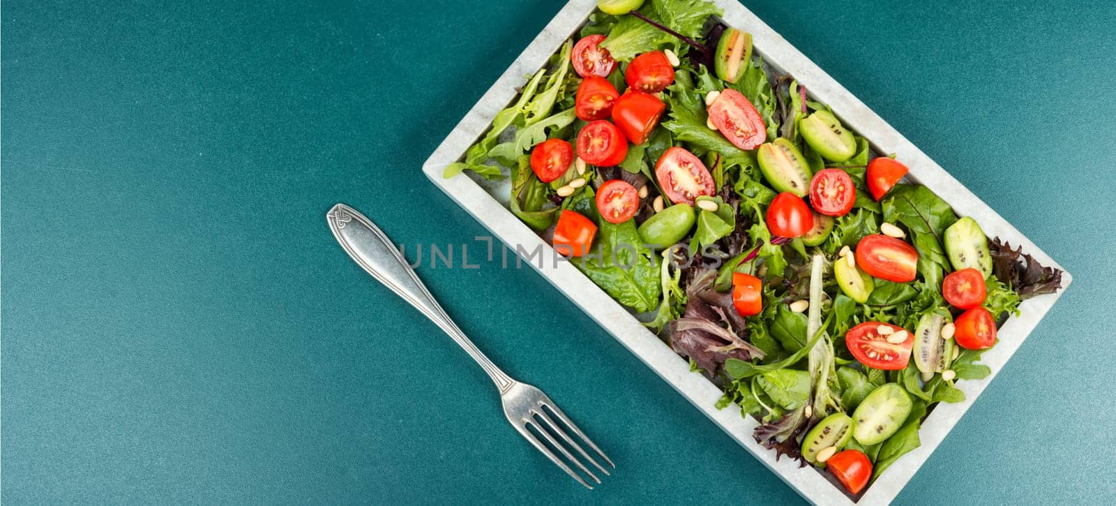 Tasty salad with tomatoes, different lettuce and pine nuts. Concept for a healthy food. Free space for your text.
